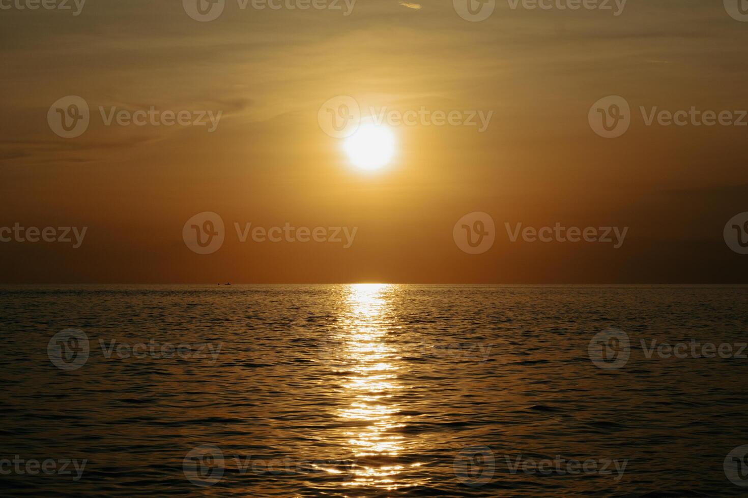 Sunset over the sea. The sun is reflected in the water. photo