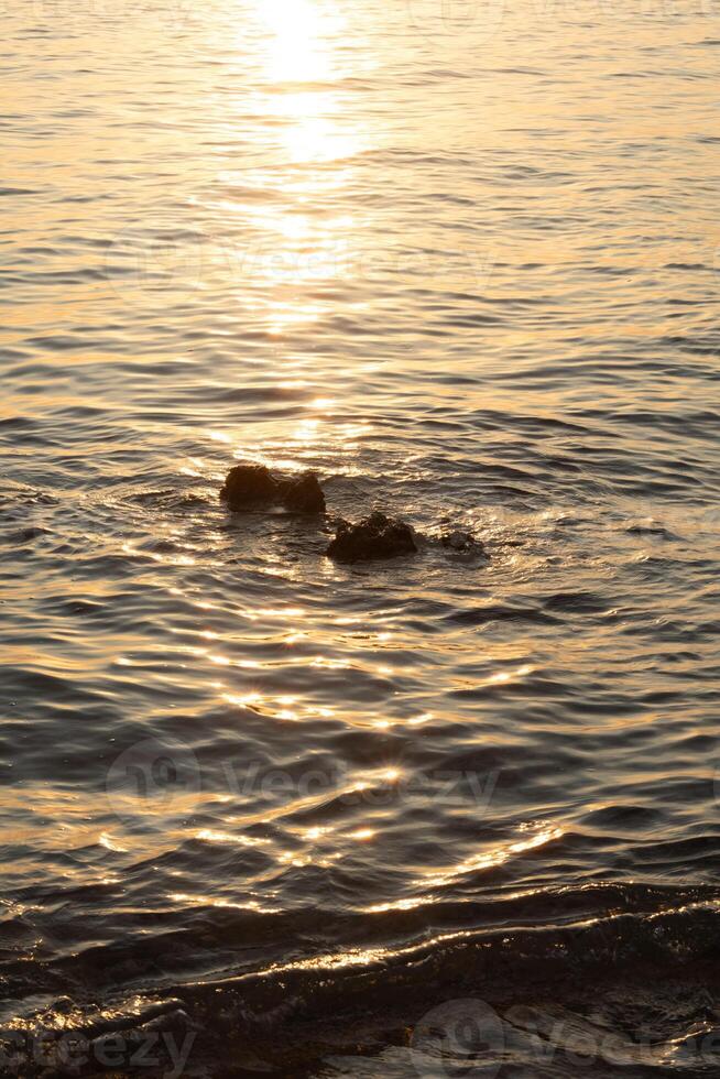 Sunset on the sea with waves and reflection in the water photo