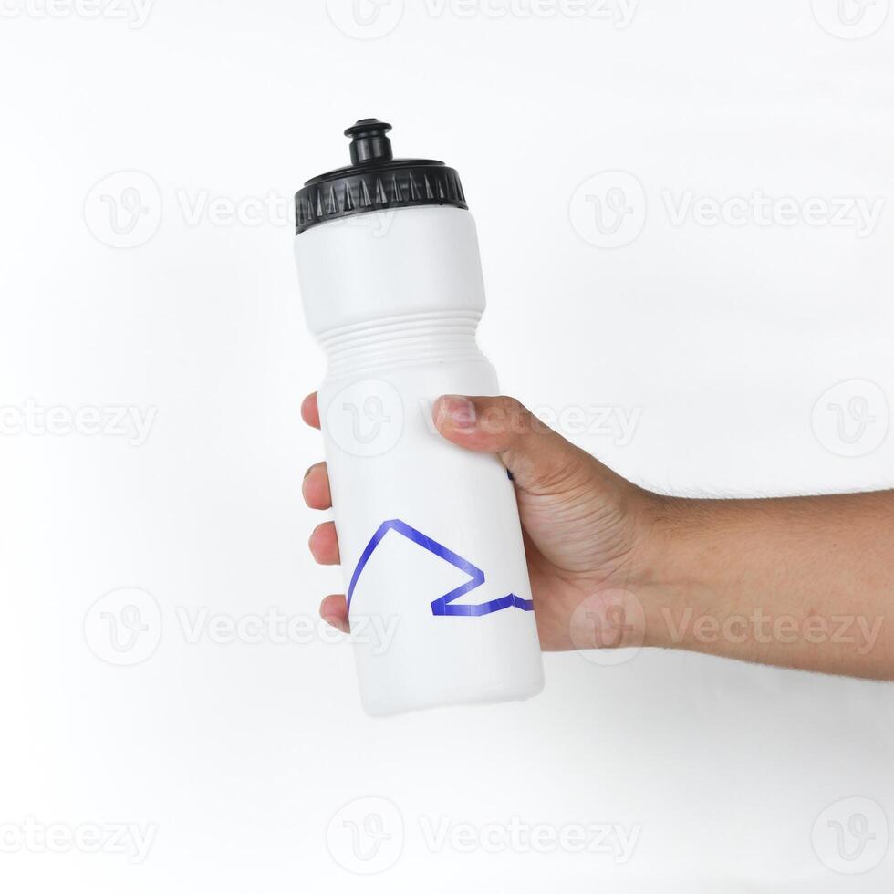 Hand holding a sports water bottle isolated on white background photo