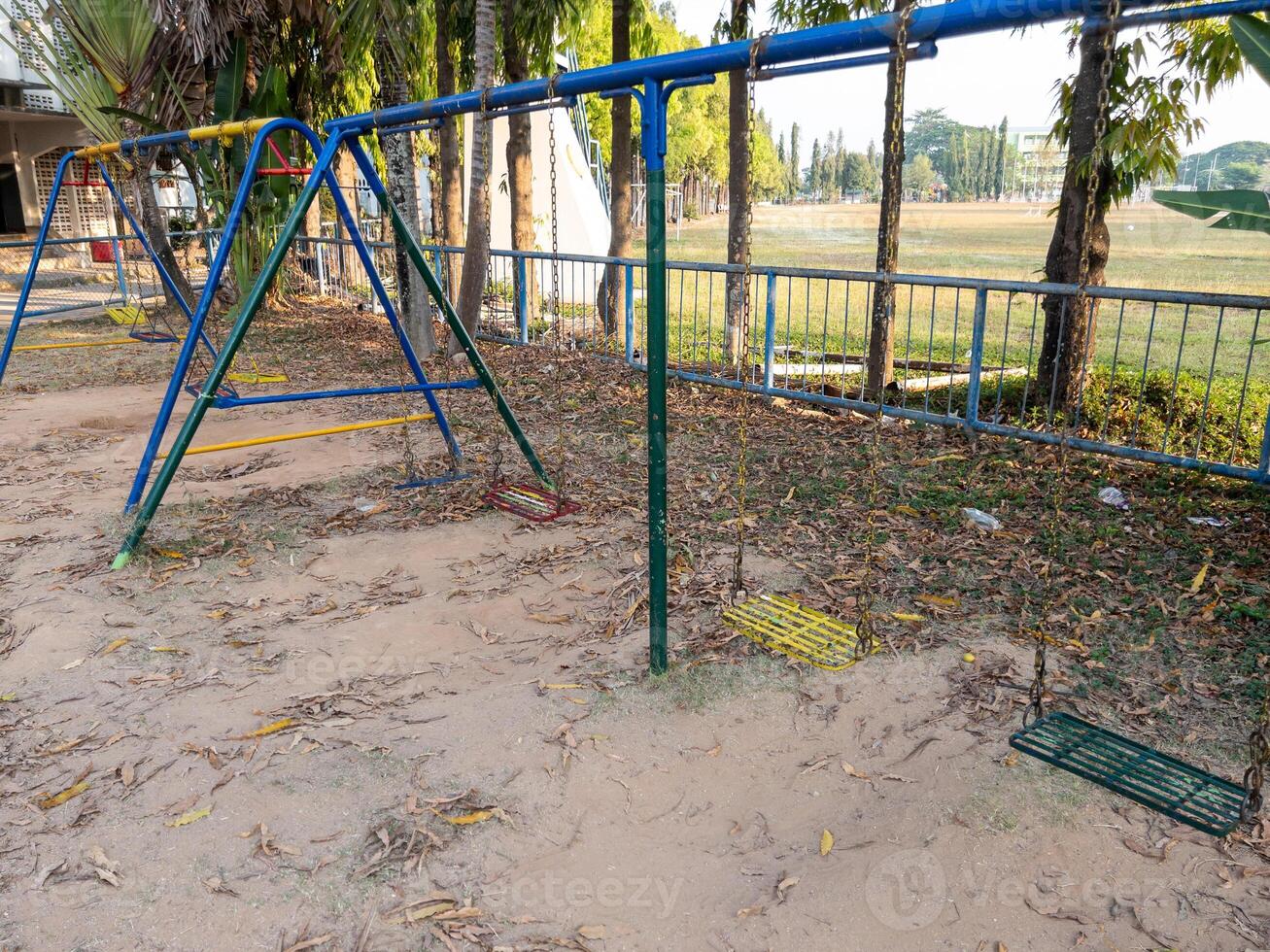The old metal swings are arranged in the playground. photo