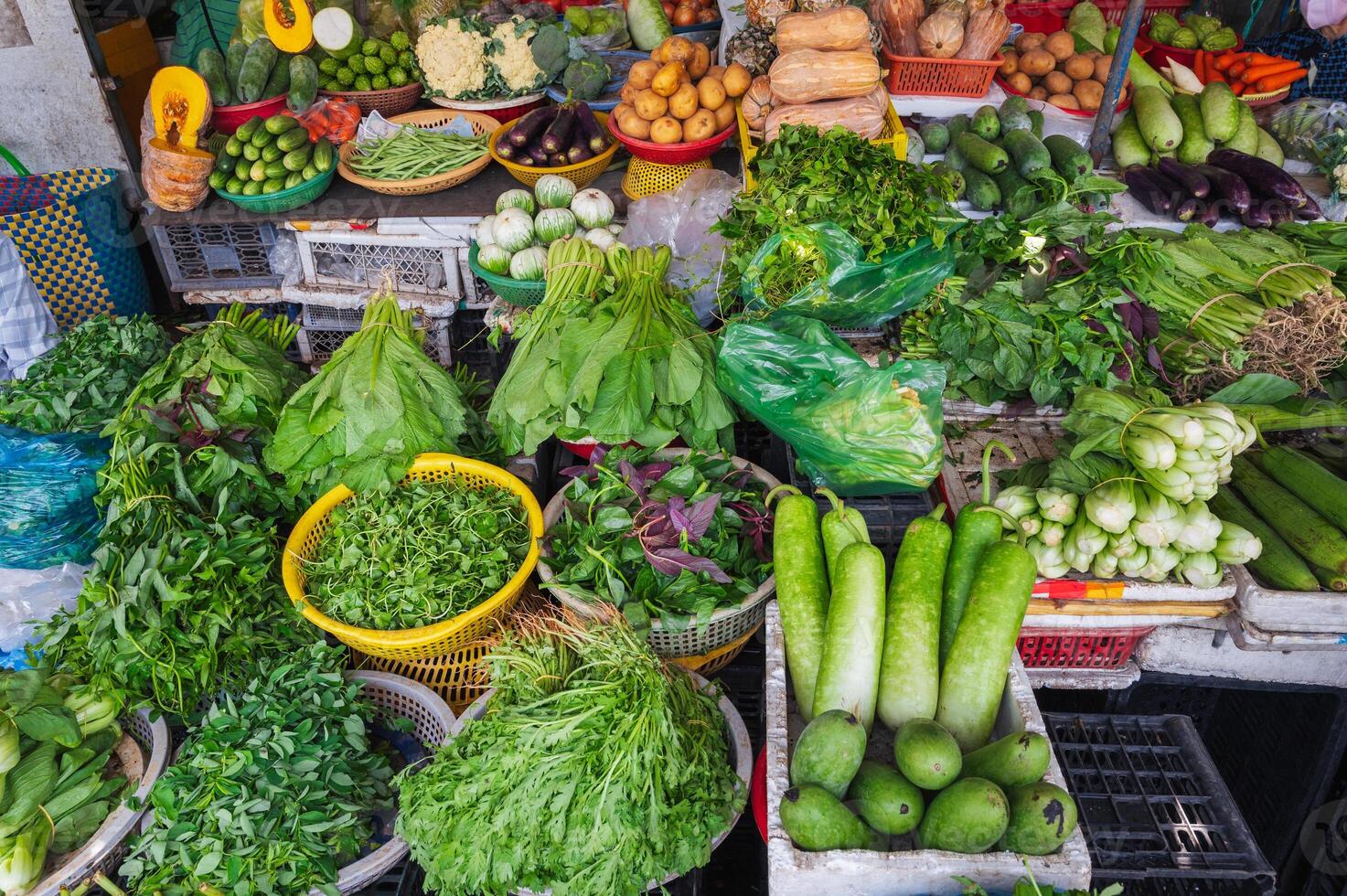 Various vegetables and herbs on the market in wicker baskets. photo