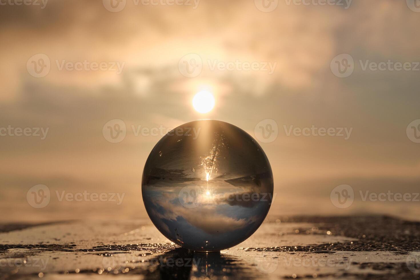 The landscape view on a nature through a glass ball with a sun in the background creative photography photo
