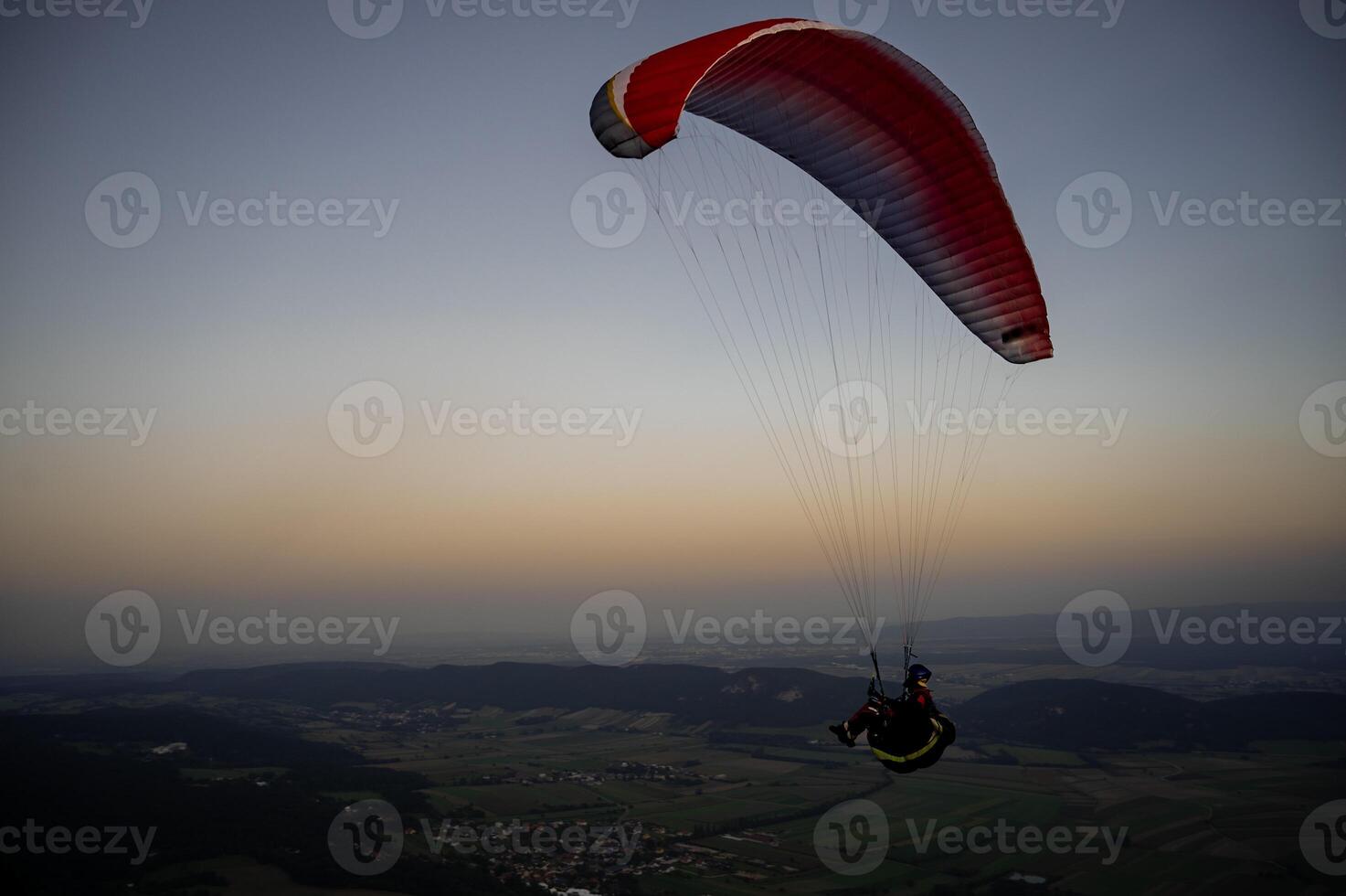 Paragliding concept, a paraglider pilot fly in the sky on the nature landscape background. photo