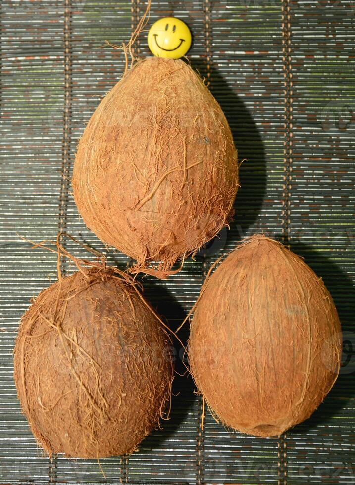 Three coconuts with a smiley face on top photo
