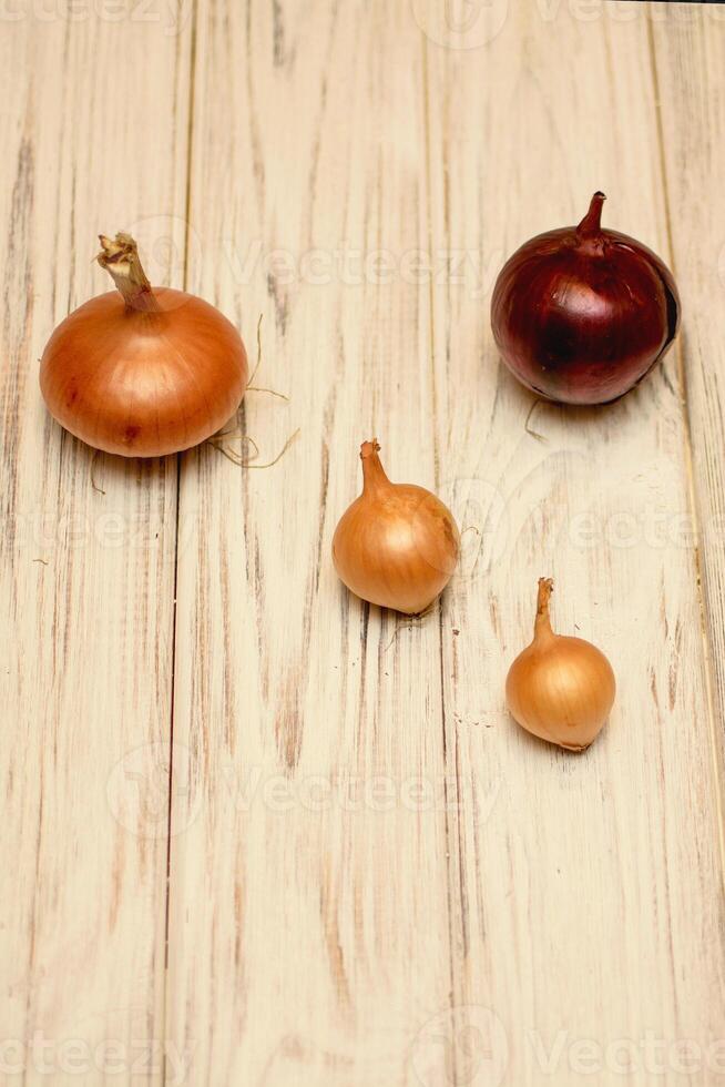 A group of onions on a wooden surface photo