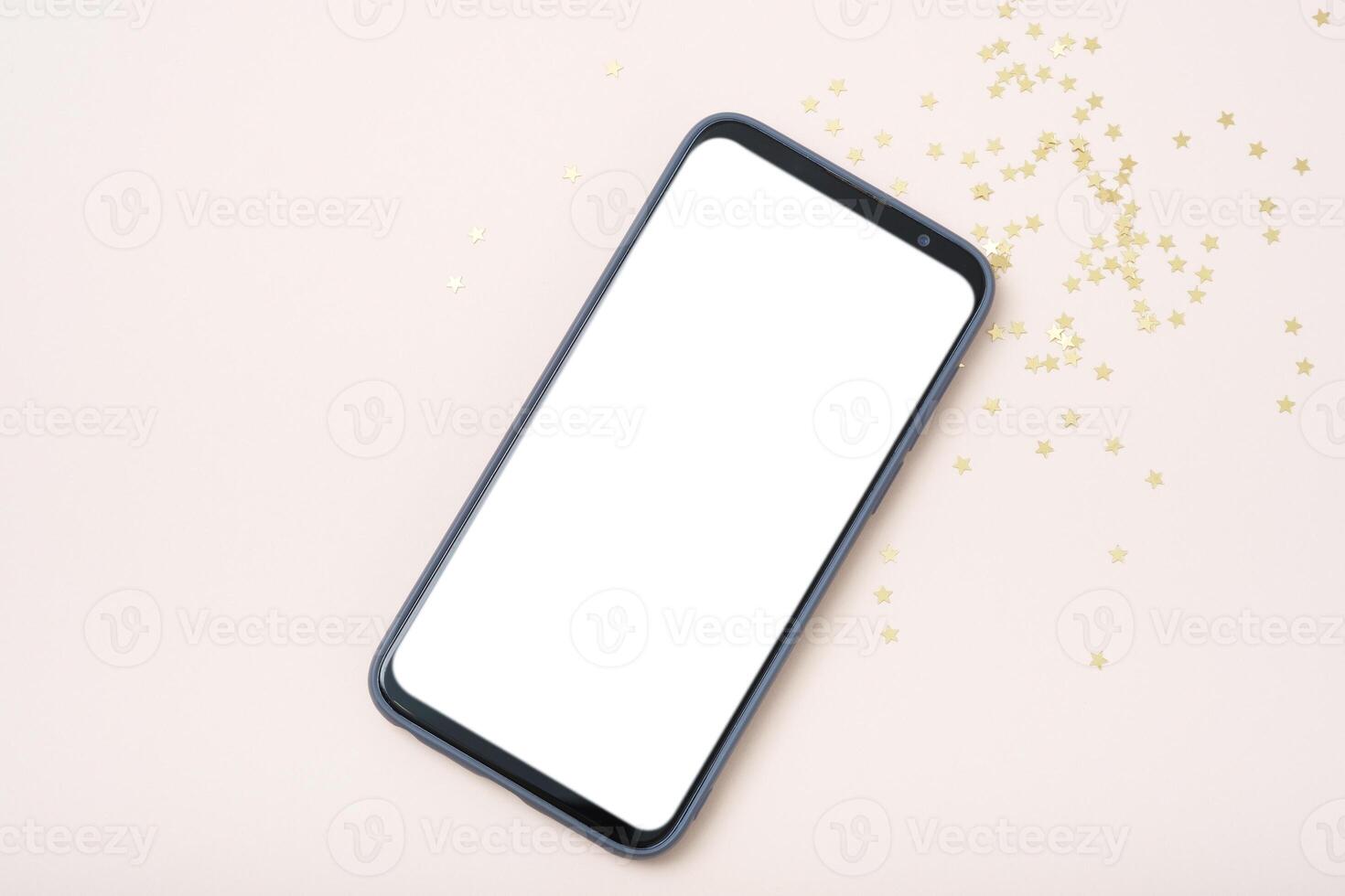 Modern smartphone with mockup on beige background with christmas decoration photo