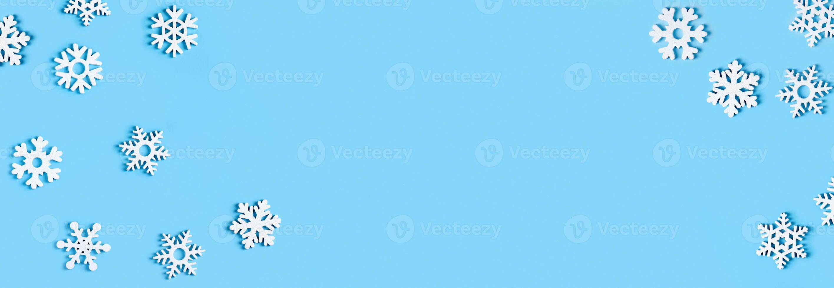Blue Christmas background with white wooden snowflakes. Flat lay banner, poster with copy space photo