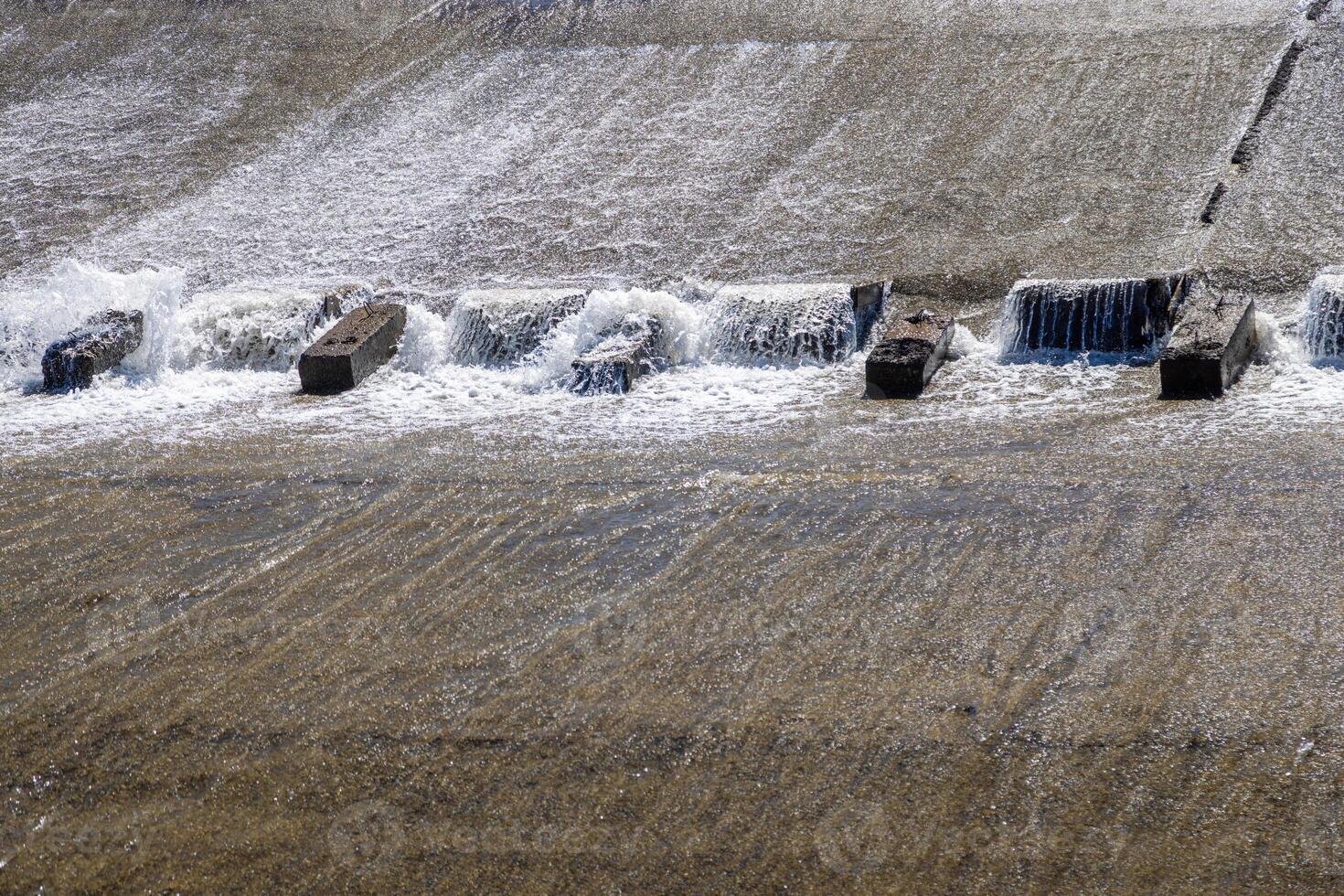 chute dentate blocks in concrete water spillway channel photo