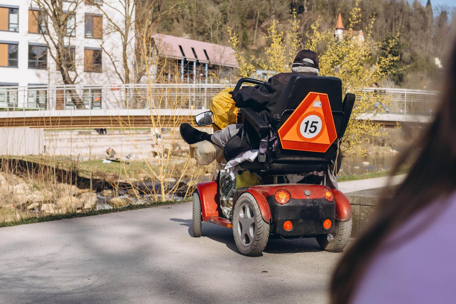 Germany, Schwabisch Gmund, March 9,2024.Person in a specialized mobility scooter for disabilities, driving through a park setting photo