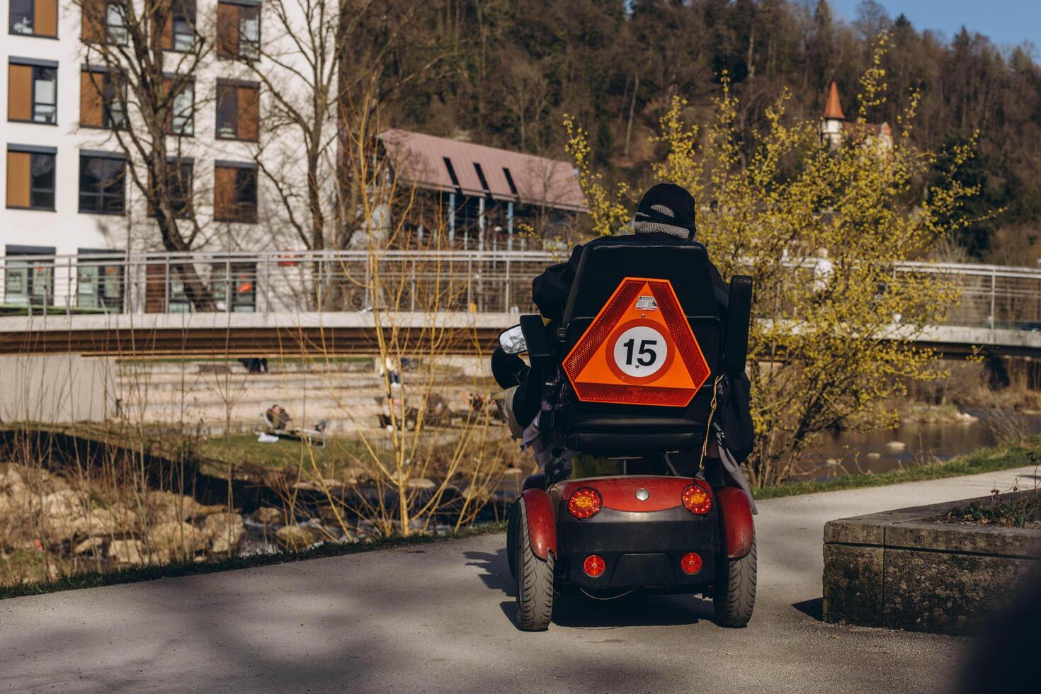 Germany, Schwabisch Gmund, March 9,2024.Person in a specialized mobility scooter for disabilities, driving through a park setting photo