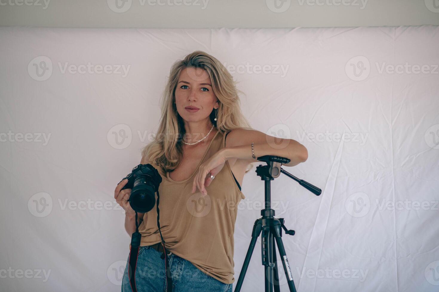 A female photographer confidently posing with her camera in a professional studio, ready to capture stunning images photo