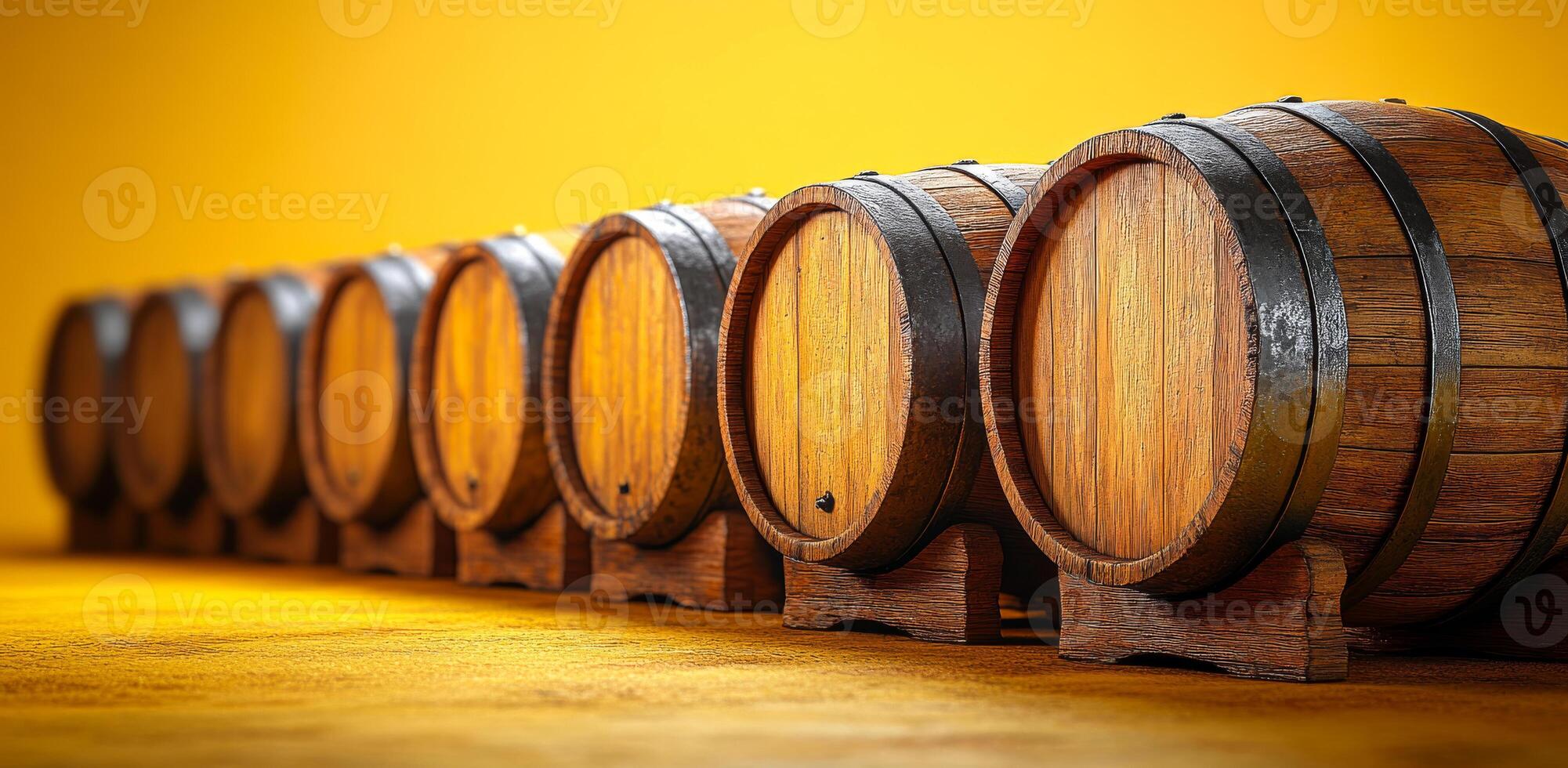 A row of wooden barrels with a yellow background. The barrels are lined up and appear to be empty photo