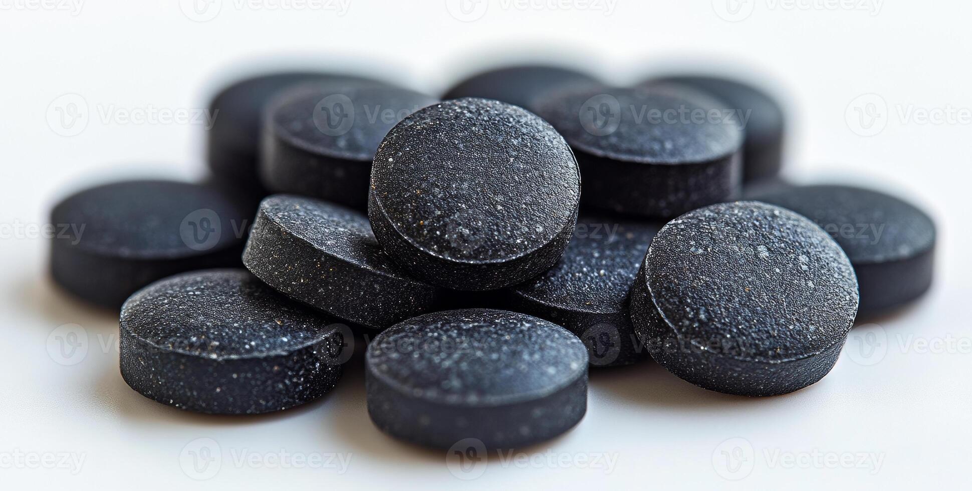 A pile of black pills with a lot of white space between them. The pills are small and black, and they are piled on top of each other. Concept of organization and order photo