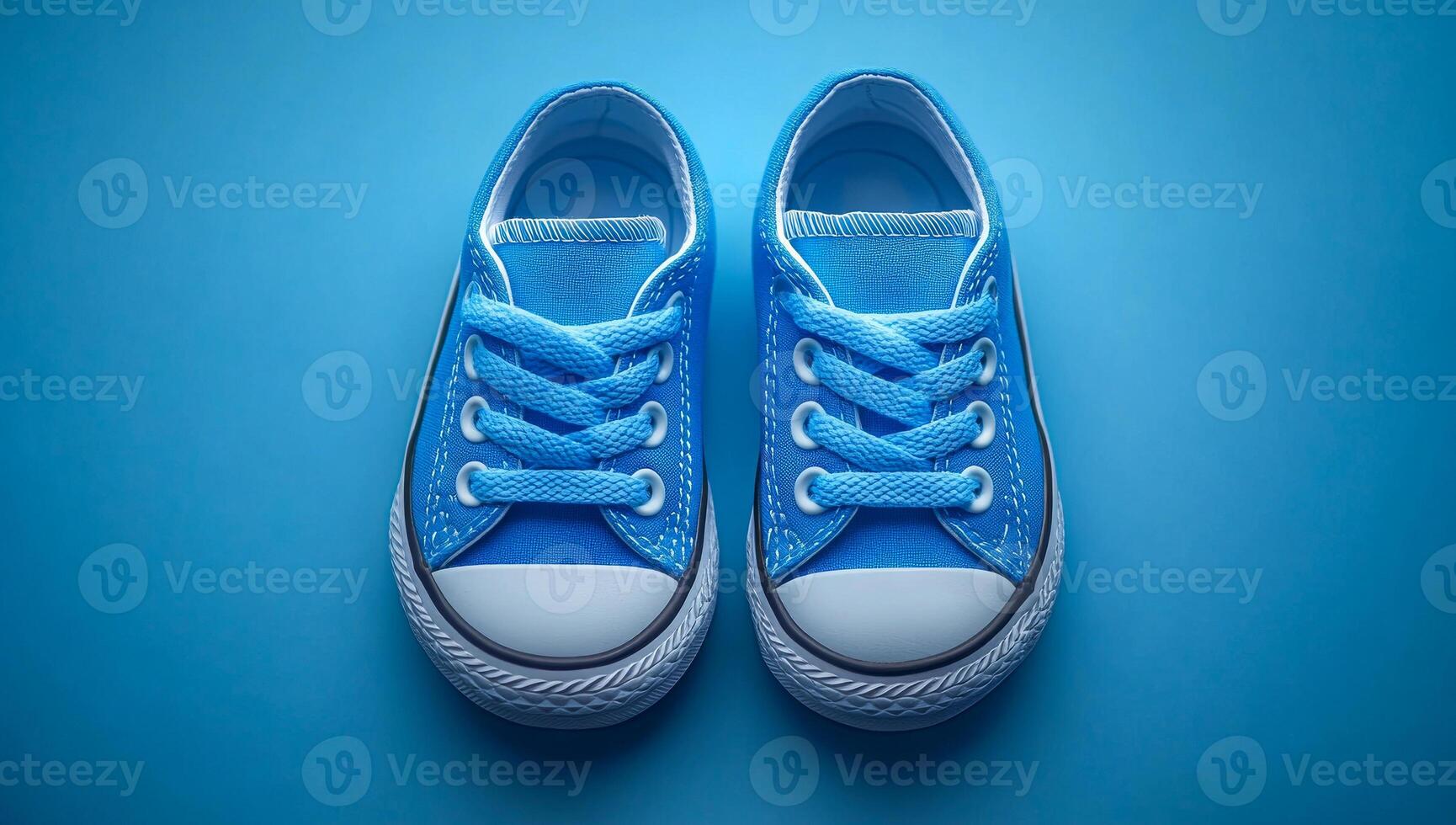 Two blue Converse sneakers are shown on a blue background. The sneakers are the same color and are positioned next to each other photo