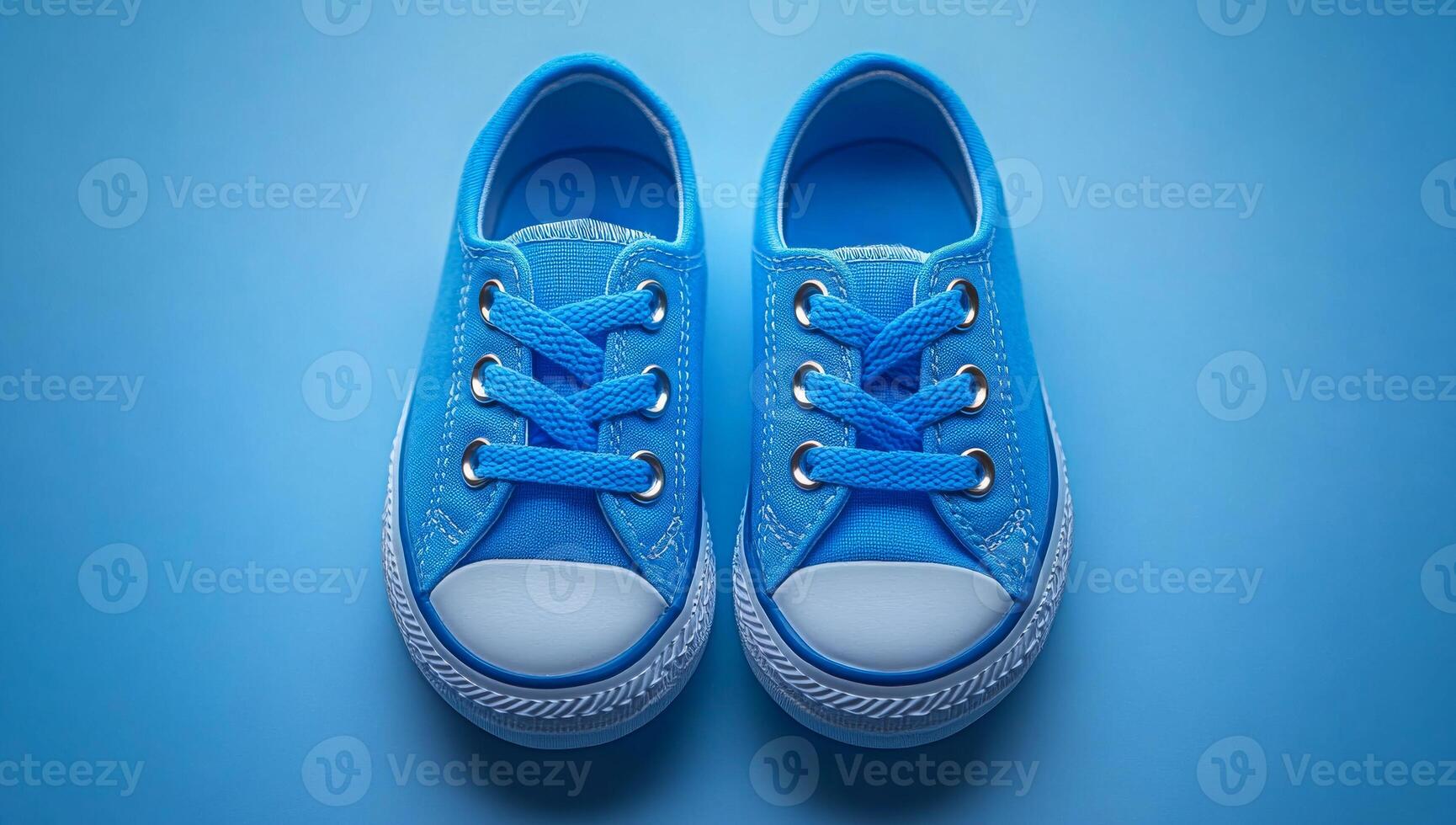Two blue shoes with white laces. The shoes are small and cute photo