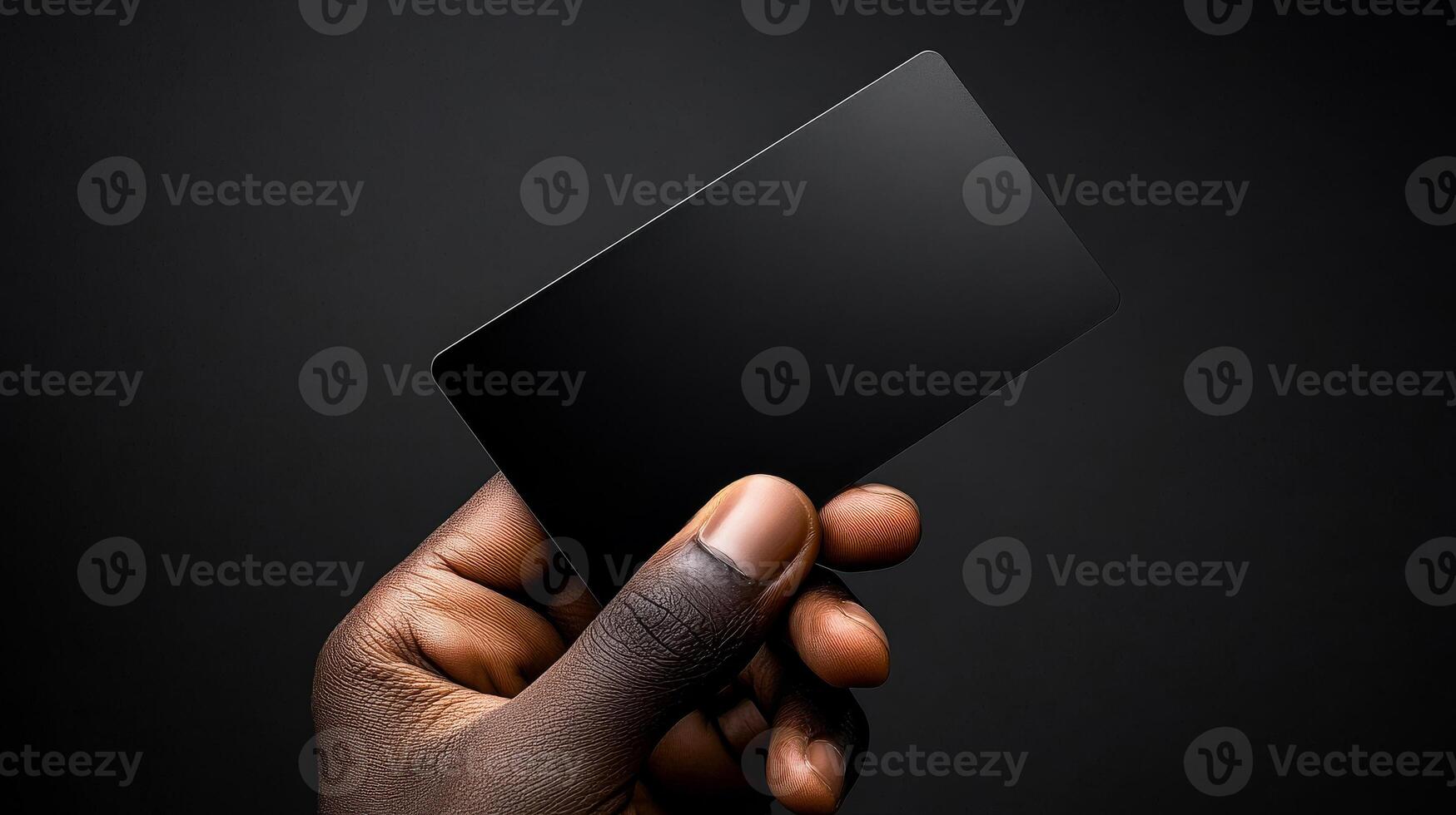 A hand holding a black card. The card is black and has no writing on it. The hand is holding the card in a way that it is almost as if it is being presented to someone photo