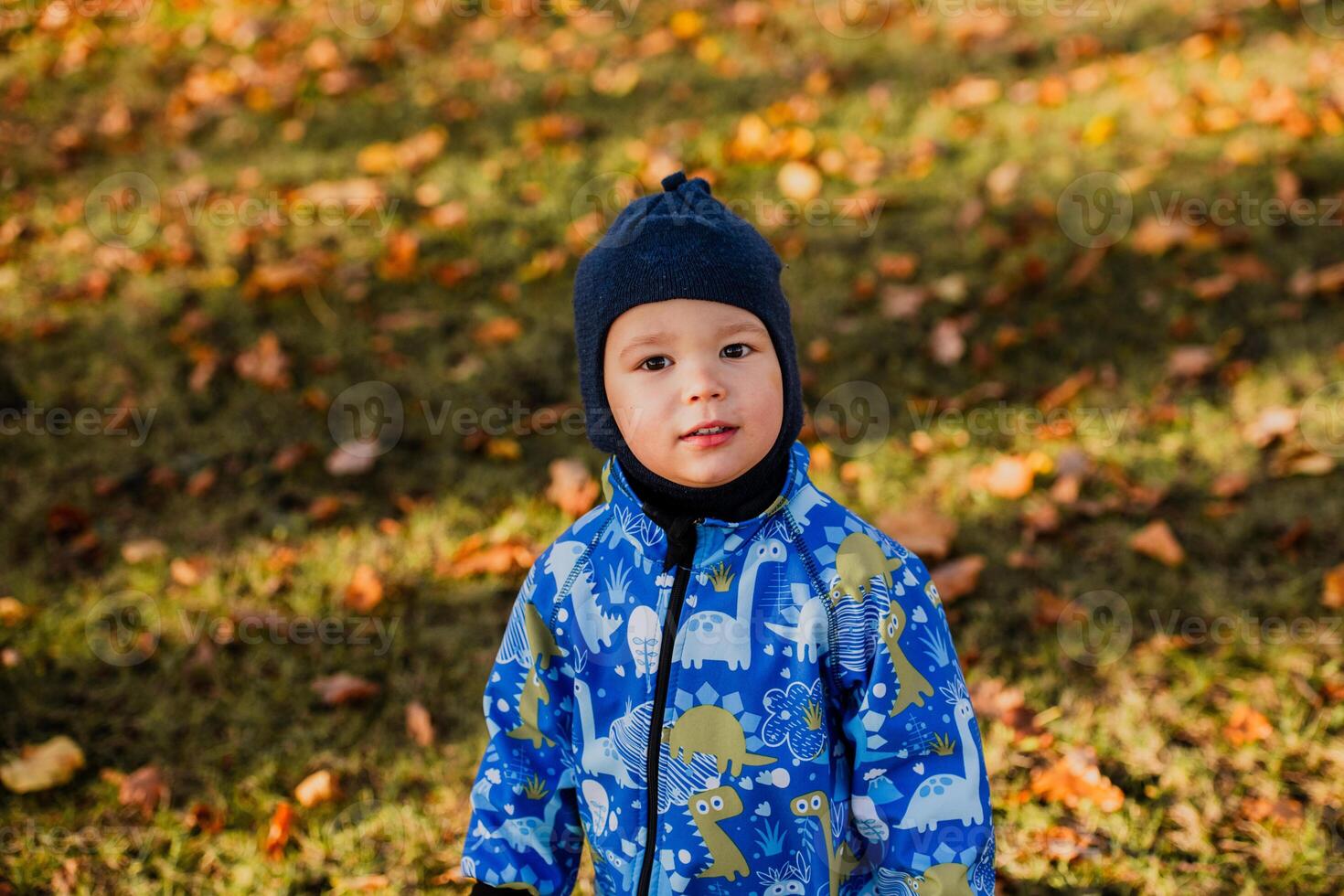A joyful little boy in his winter coat and hat plays happily in the park, surrounded by the love and warmth of his smiling parents photo