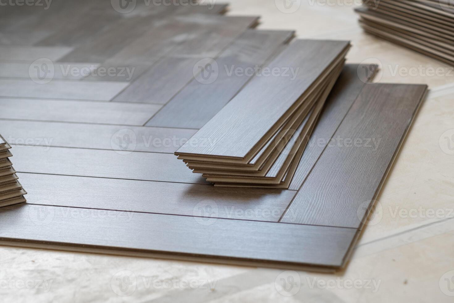 Worker installing laminate flooring in a residential apartment. Tools, planks photo