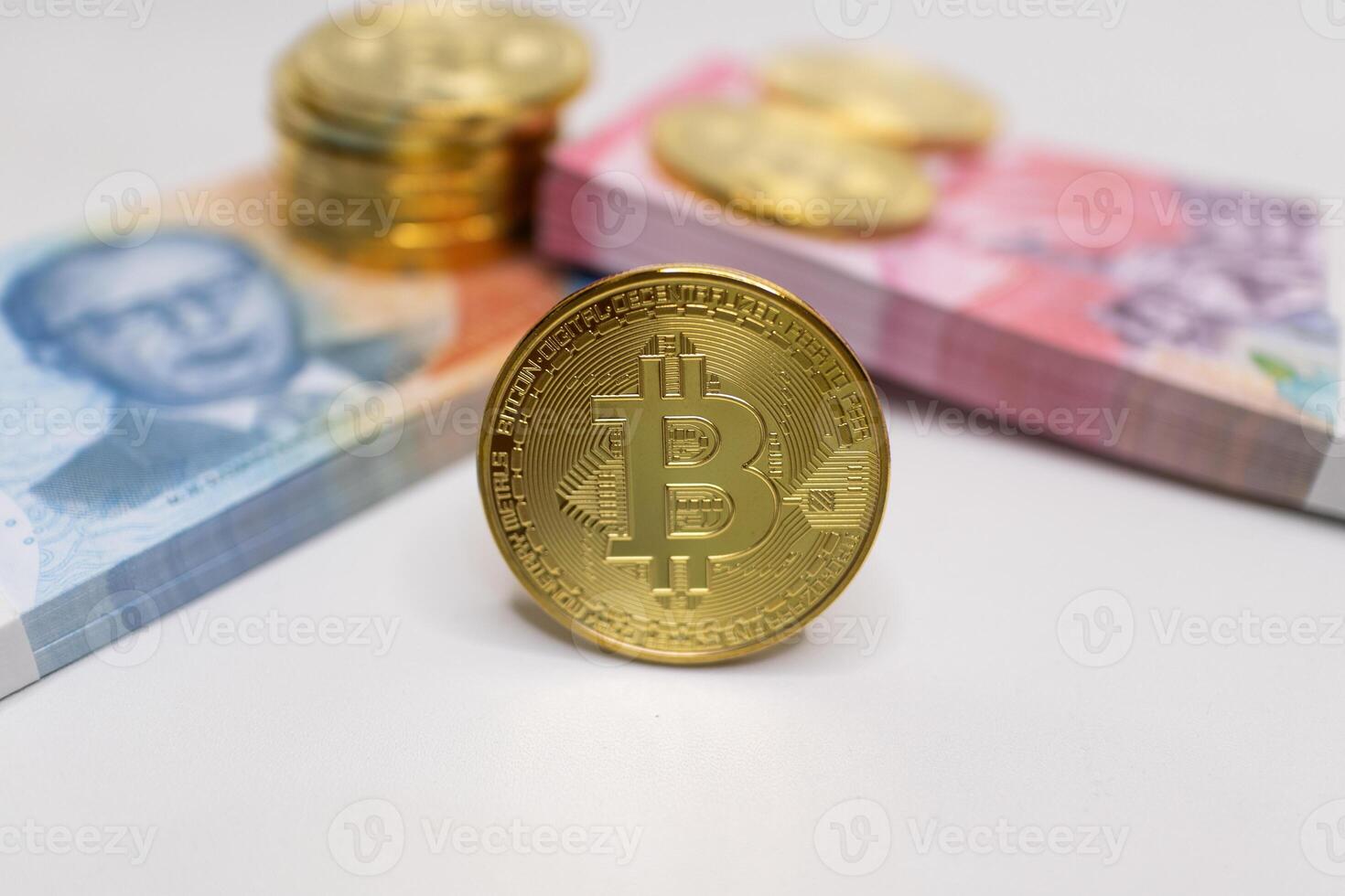 Gold Bitcoin with Indonesian Rupiah Banknotes in Background . photo