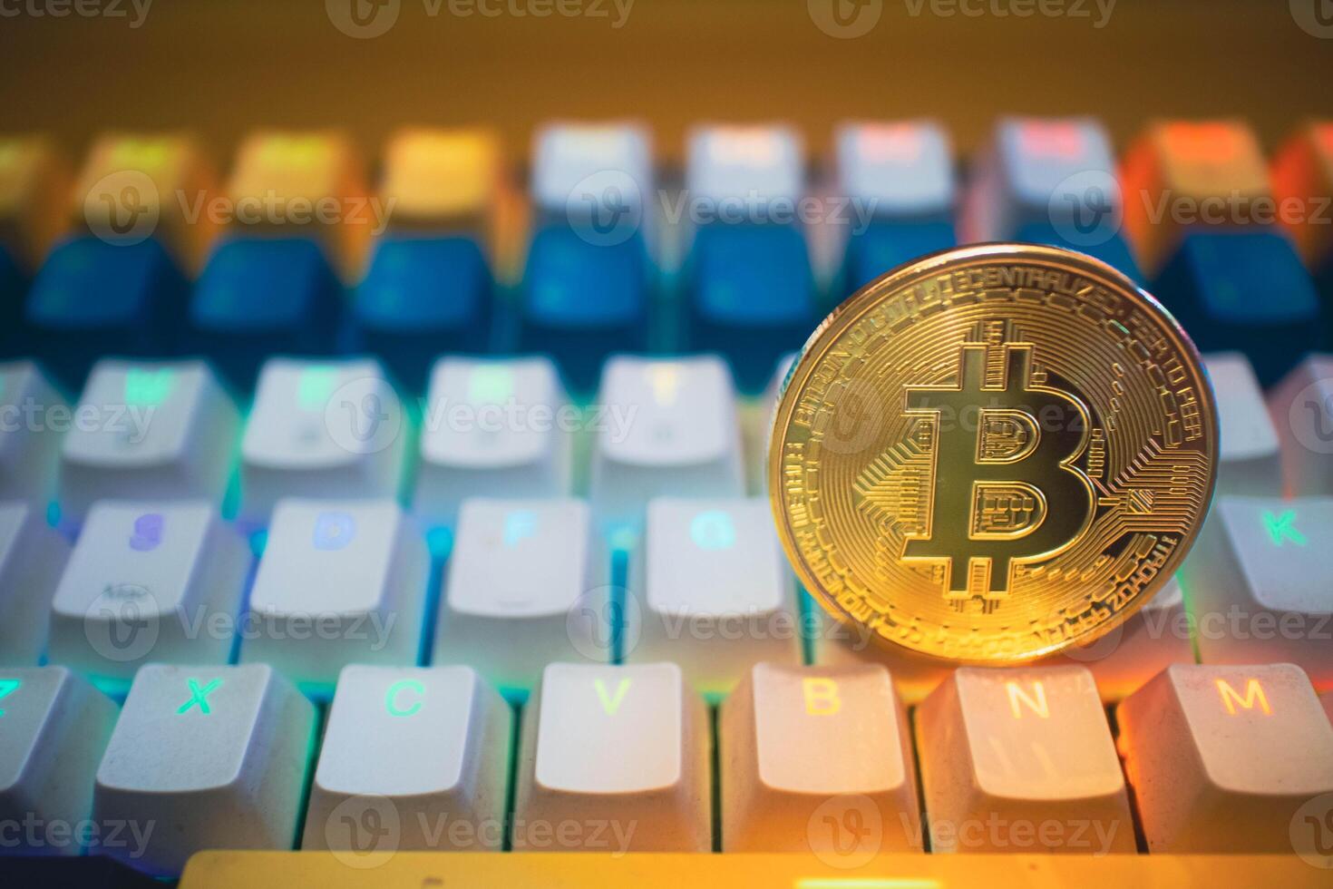 Golden Bitcoin on a Colorful Gaming Keyboard. photo