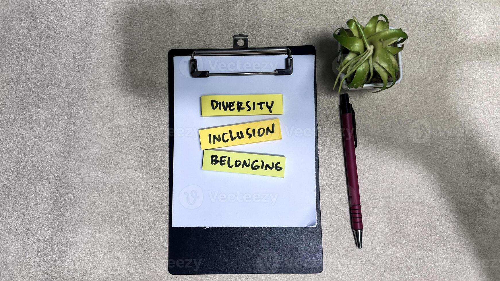 Concept of Diversity, Inclusion, Belonging write on sticky notes isolated on Wooden Table. photo