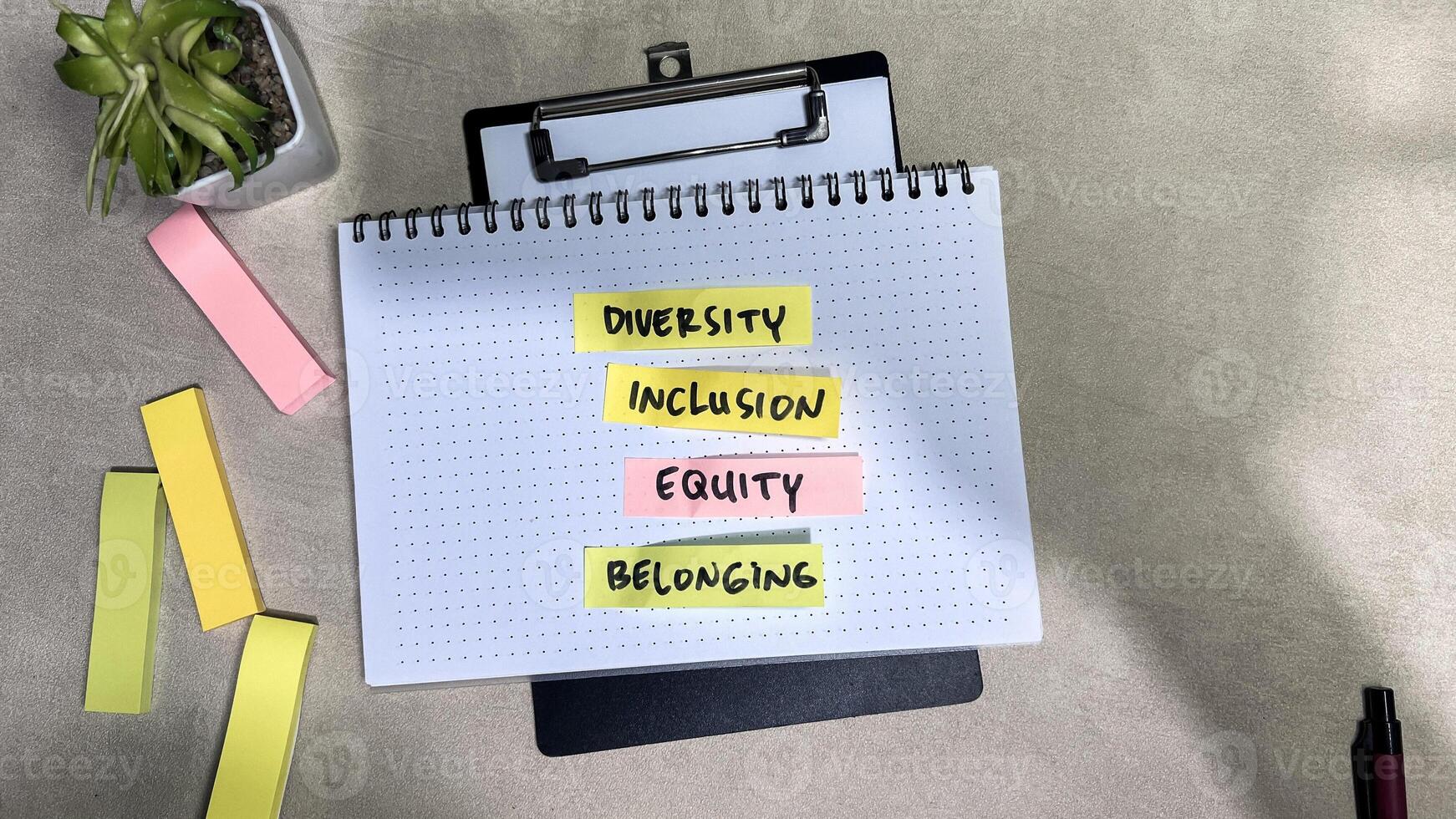Concept of Diversity, Inlcusion, Equity, Belonging write on sticky notes isolated on Wooden Table. photo