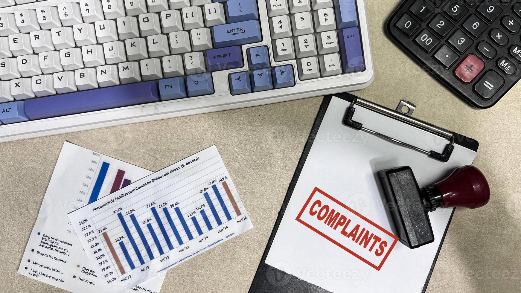 Red Handle Rubber Stamper and Complaints text on a paperwork isolated on wooden background photo
