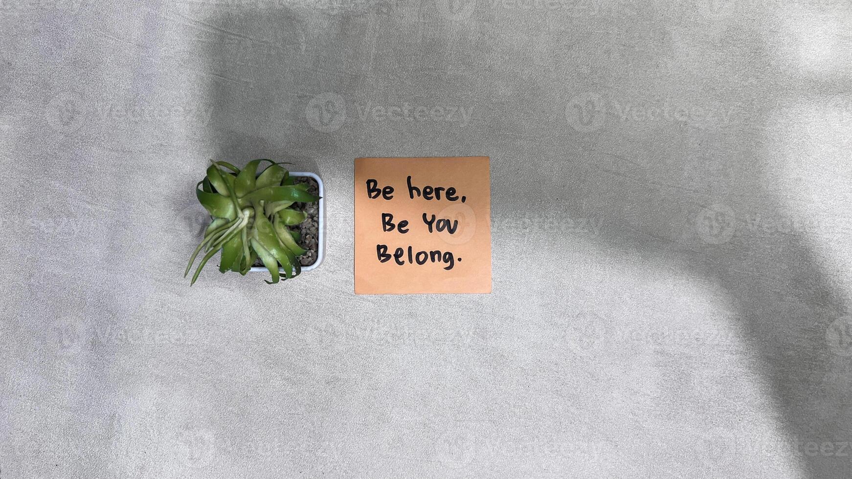 Concept of Be Here, Be You, Belong write on sticky notes isolated on Wooden Table. photo