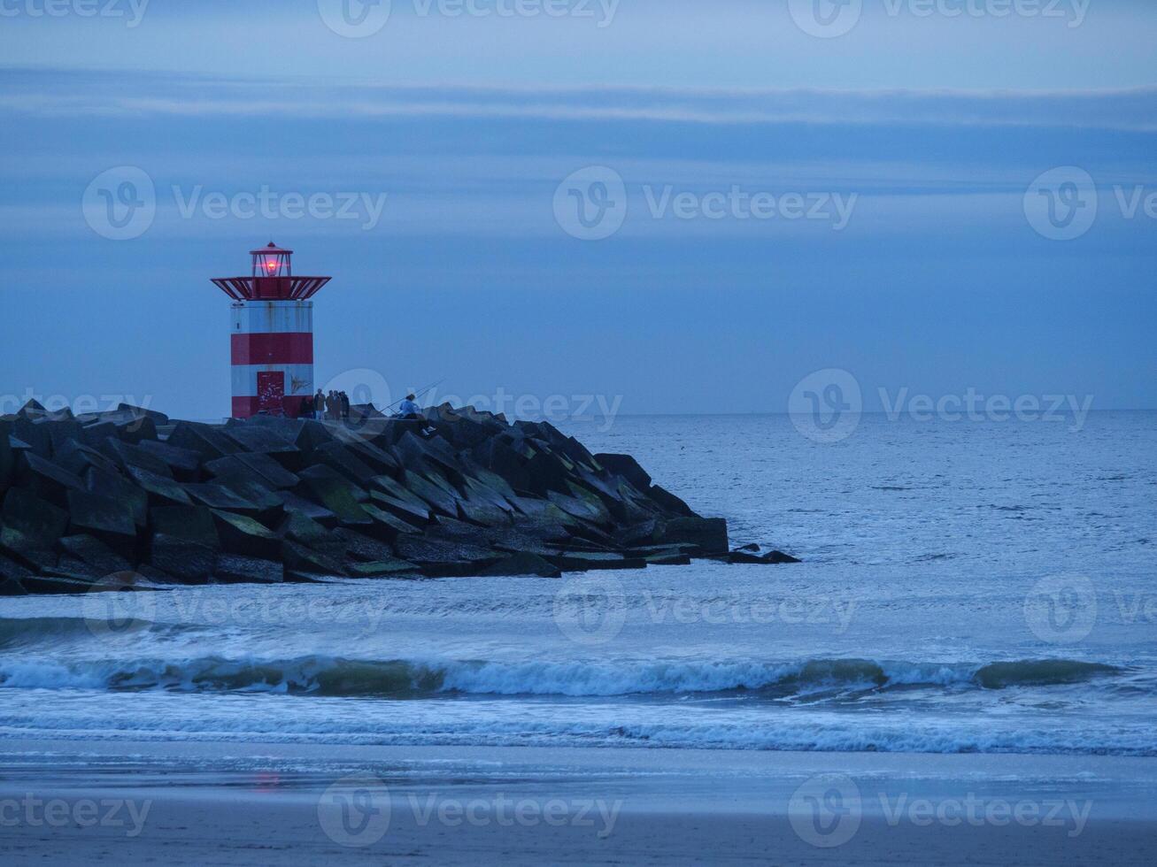 A lighthouse sitting on a rocky outcrop photo