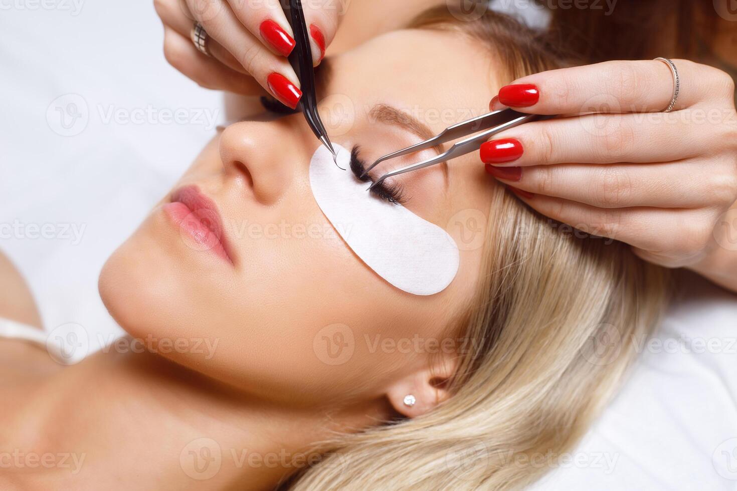 Eyelash Extension Procedure. Woman Eye with Long Eyelashes. Lashes, close up, selected focus. photo