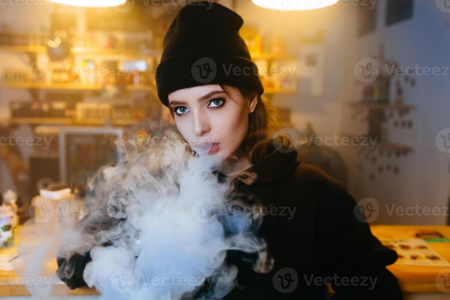 Vaping girl. Young hipster woman vape e-cig at the vapeshop. Hip-hop style. Closeup. photo