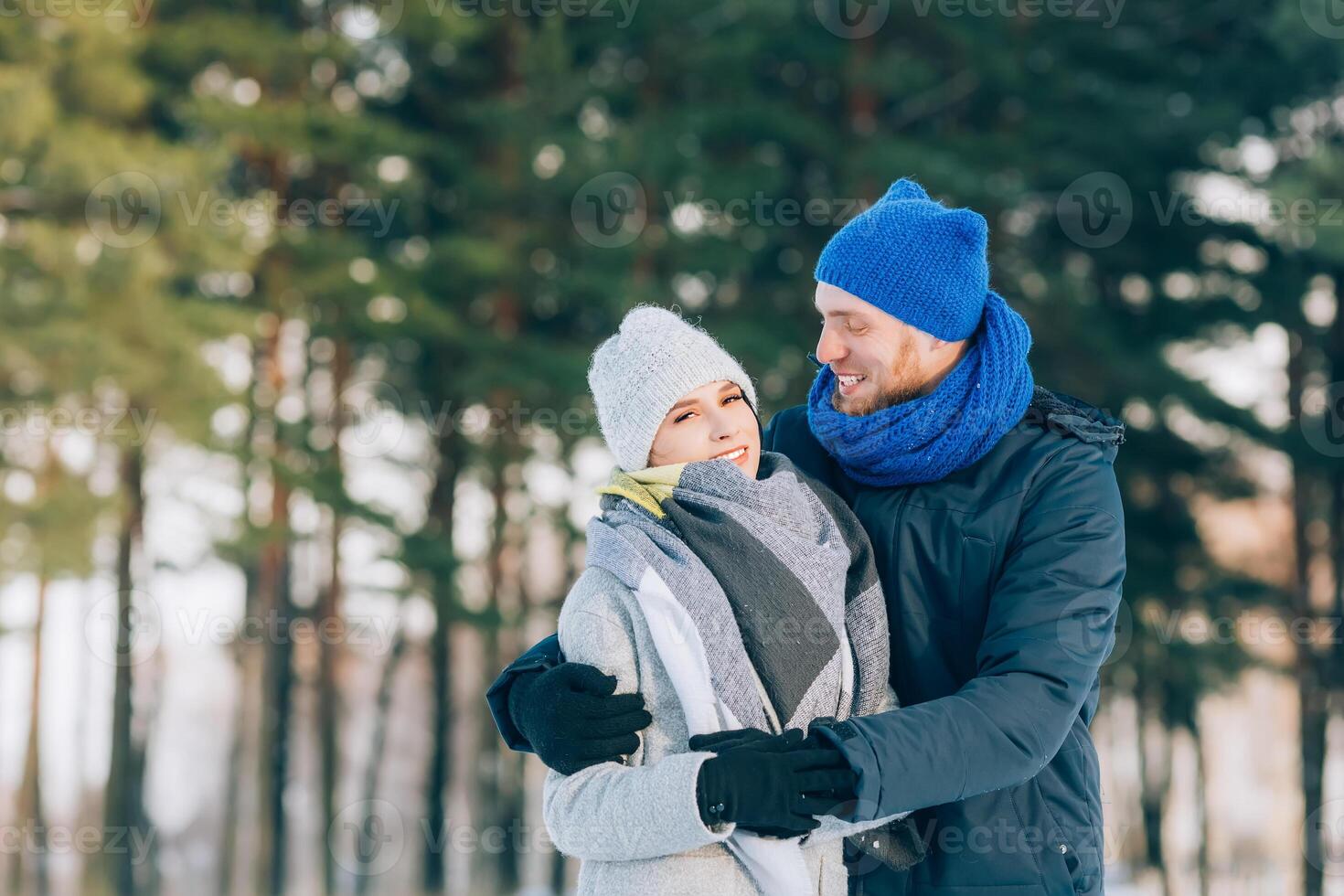 Happy Young Couple in Winter Park laughing and having fun. Family Outdoors. photo