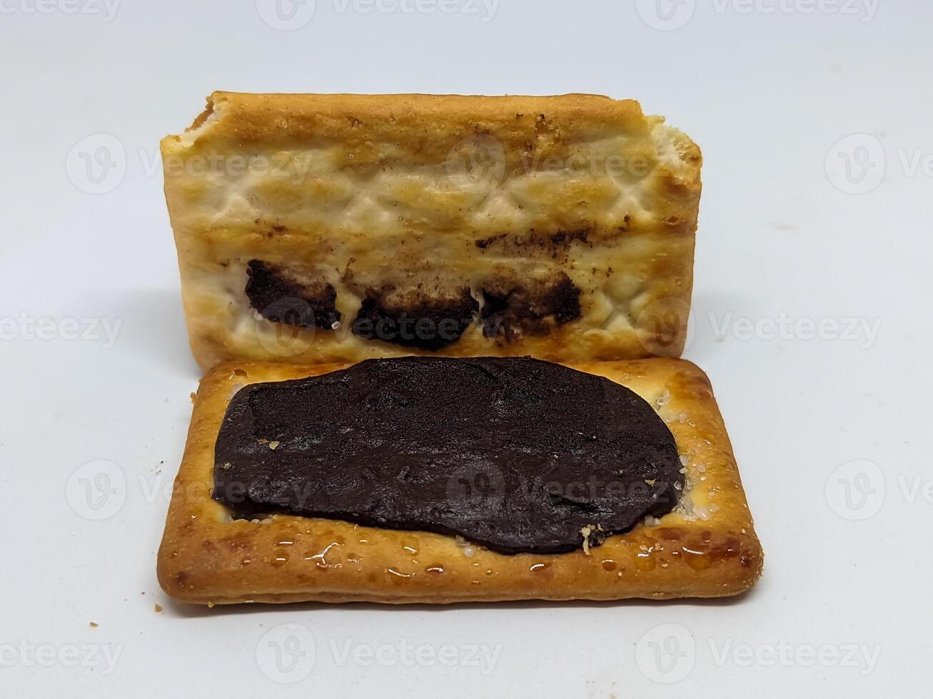 An open sandwich biscuit revealing a rich chocolate filling. The image captures the intricate textures and tempting appearance of the snack, emphasizing its indulgent and delicious nature. photo