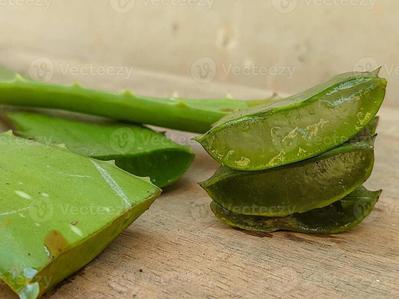 Freshly cut aloe vera on a rustic table, illustrating the plant's glossy texture and medicinal qualities, perfect for wellness and beauty applications. photo