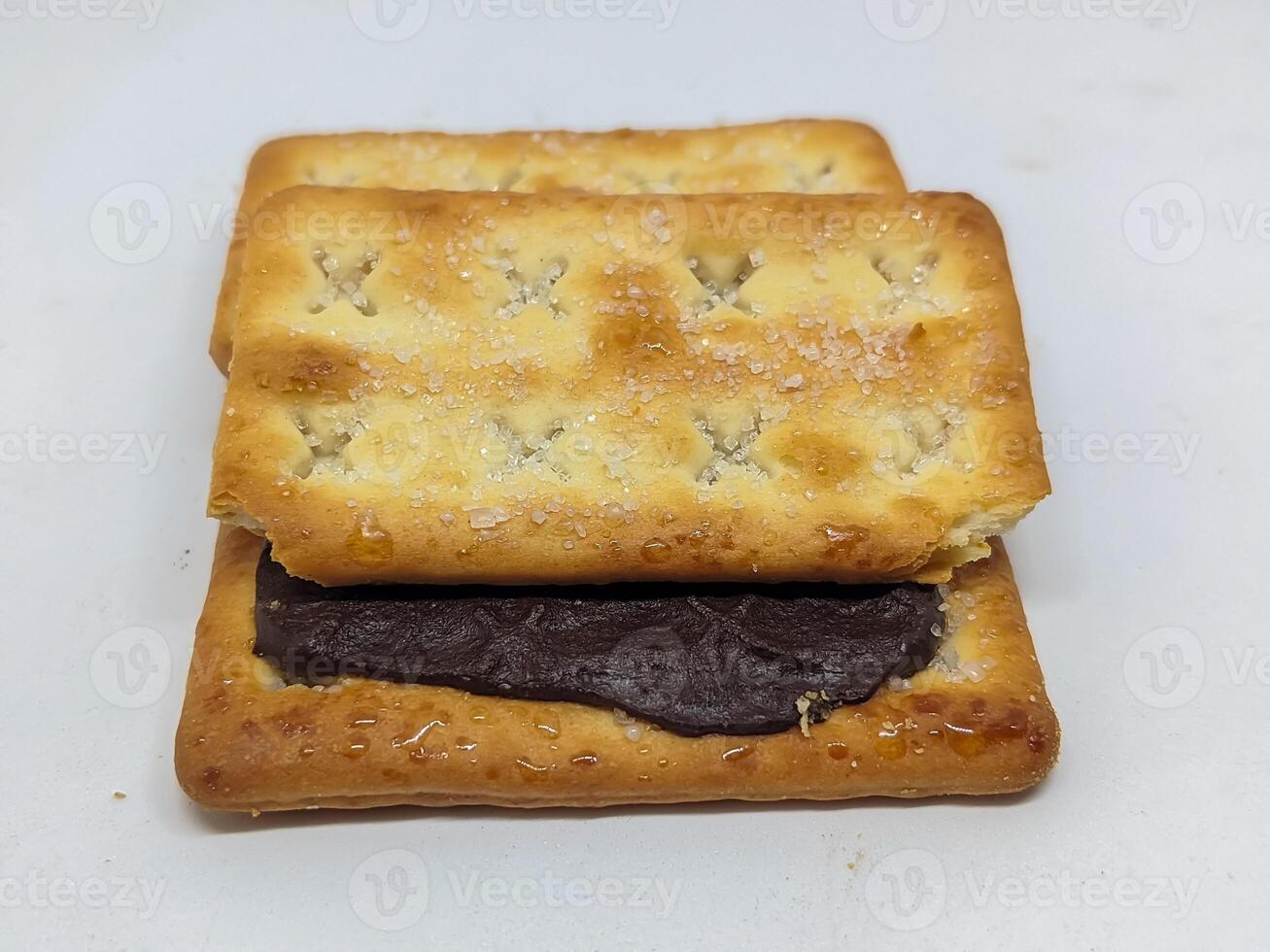 A close-up of a chocolate-filled biscuit, with one half lifted. The image captures the enticing texture contrast, perfect for showcasing a simple yet satisfying dessert. photo