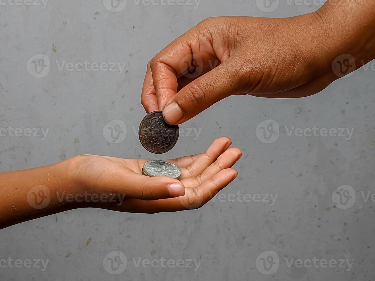 Hands exchanging coins, illustrating financial aid and interpersonal interaction. This moment depicts the essence of economic activity and mutual support in everyday life. photo