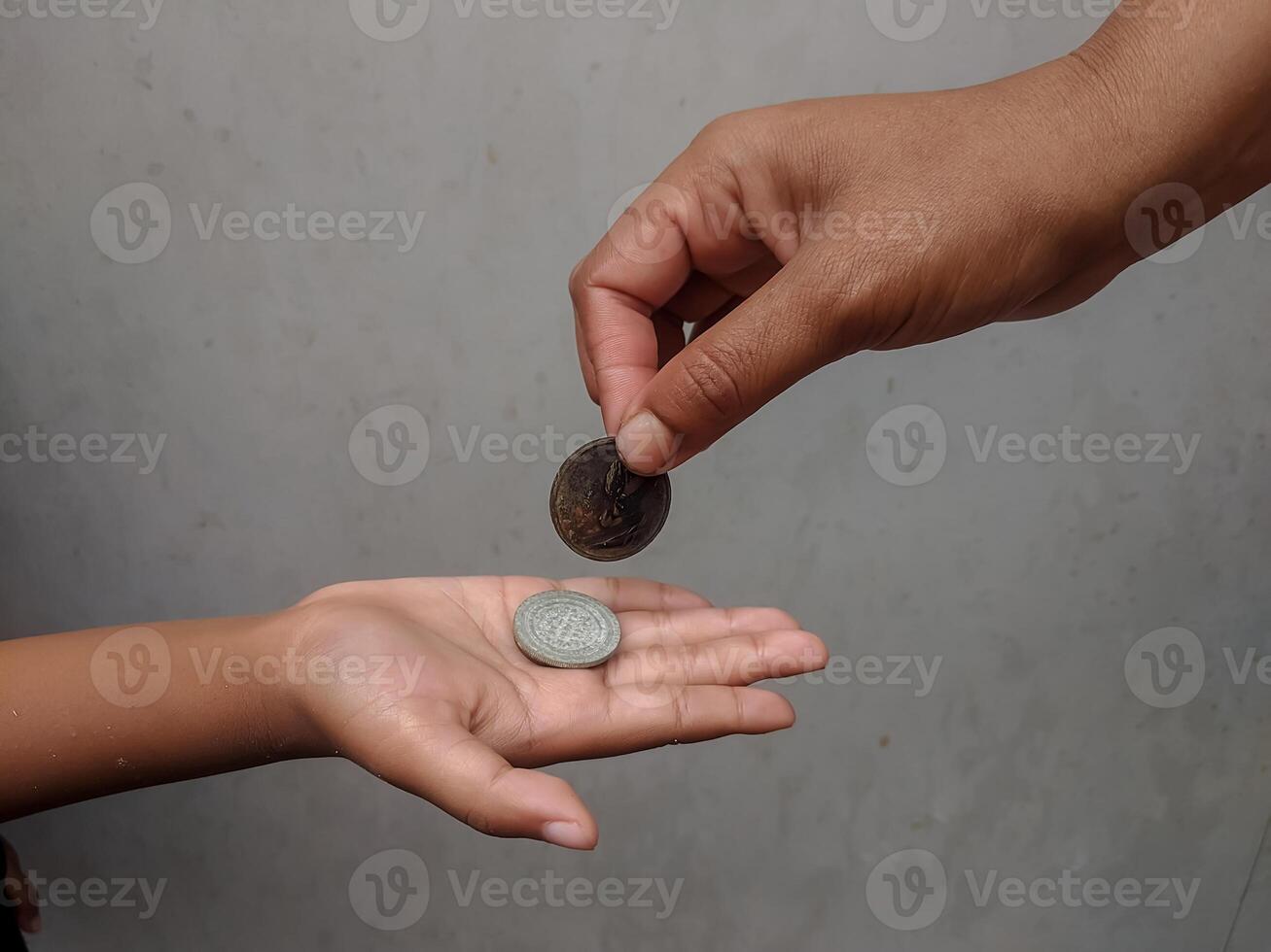 A coin being handed over from one person to another, representing concepts of assistance, trade, and value transfer. The scene reflects acts of kindness and financial support. photo
