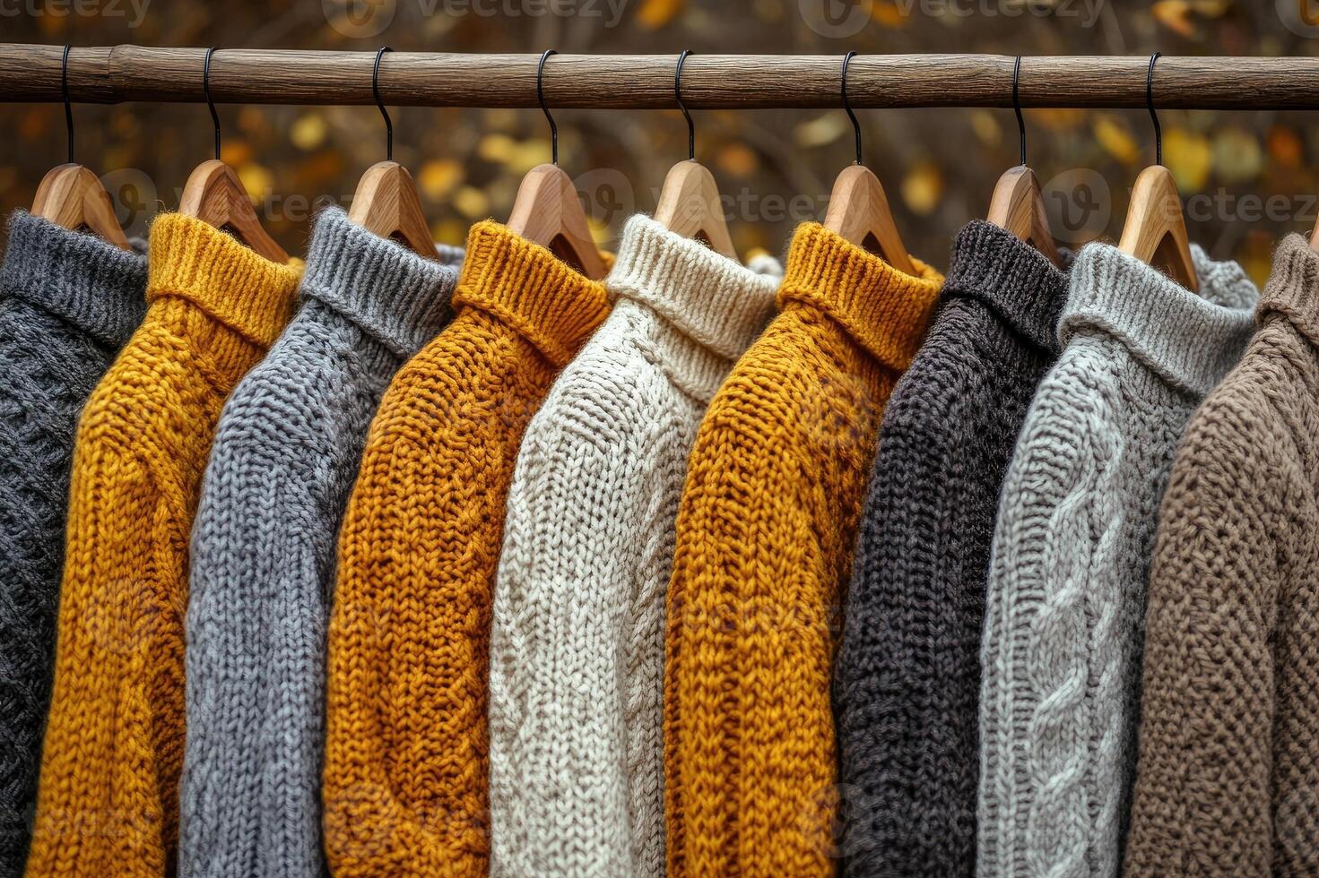 Warm knitted sweaters hanging on wooden hangers in a clothing store photo