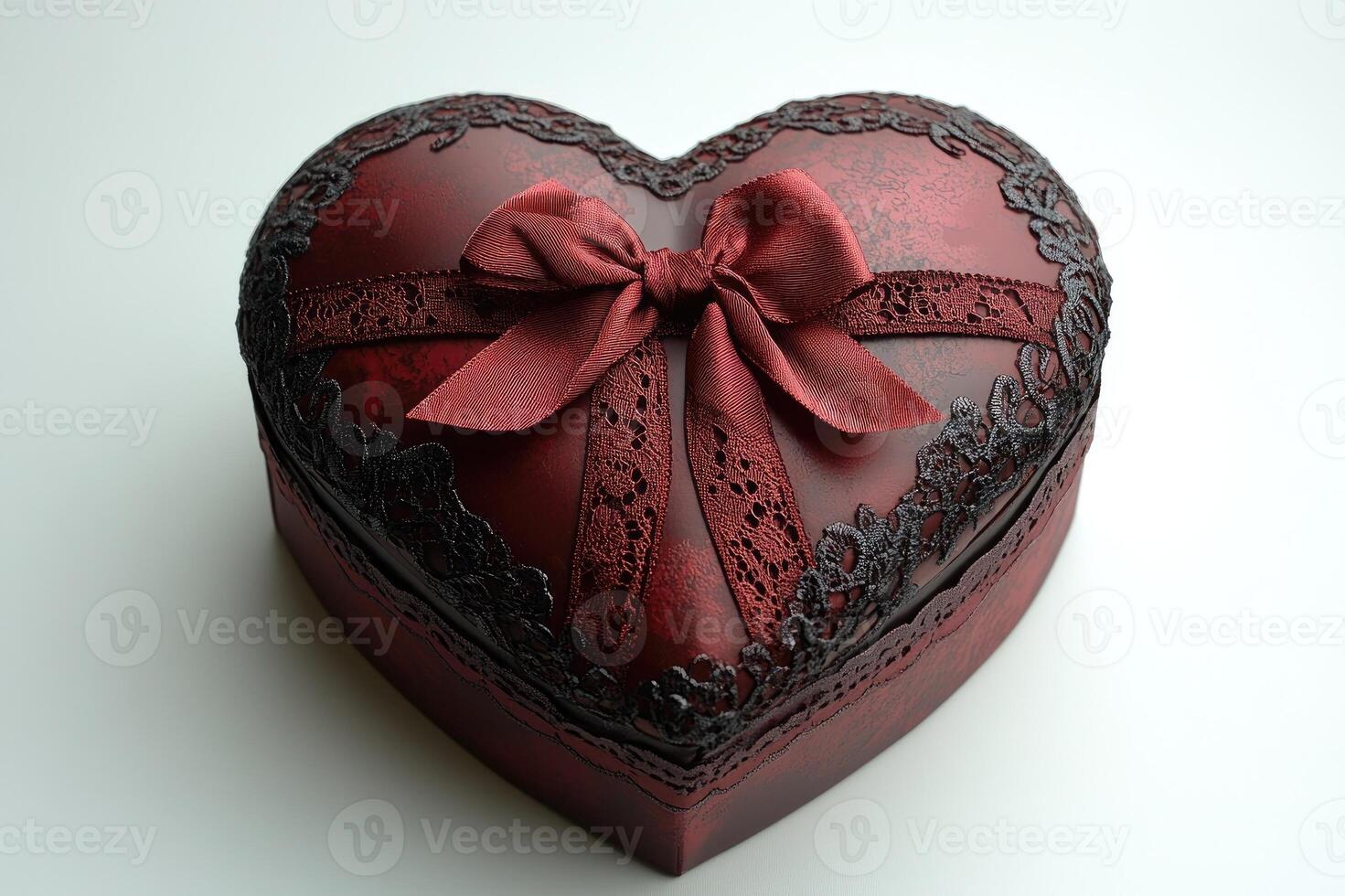 Heart shaped gift box decorated with red ribbon and black lace on white background photo