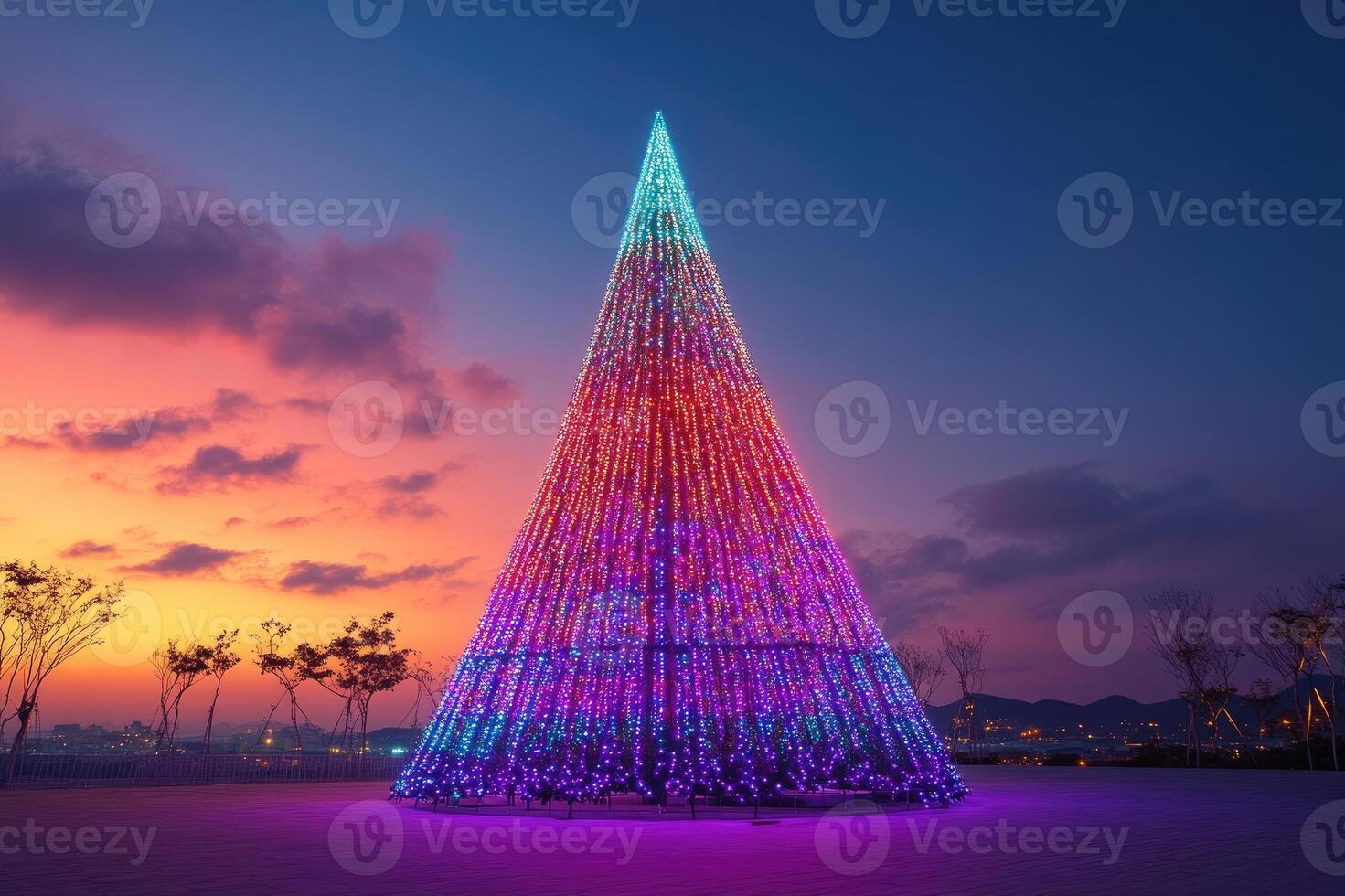 Giant christmas tree shining with colorful lights at sunset photo