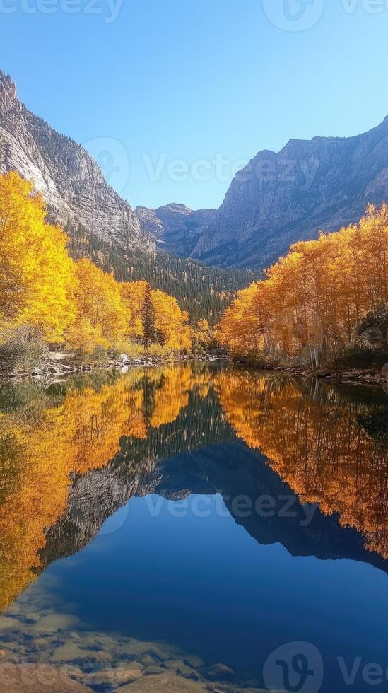 Maroon bells reflecting in crystal clear lake during peak fall foliage in aspen, colorado photo