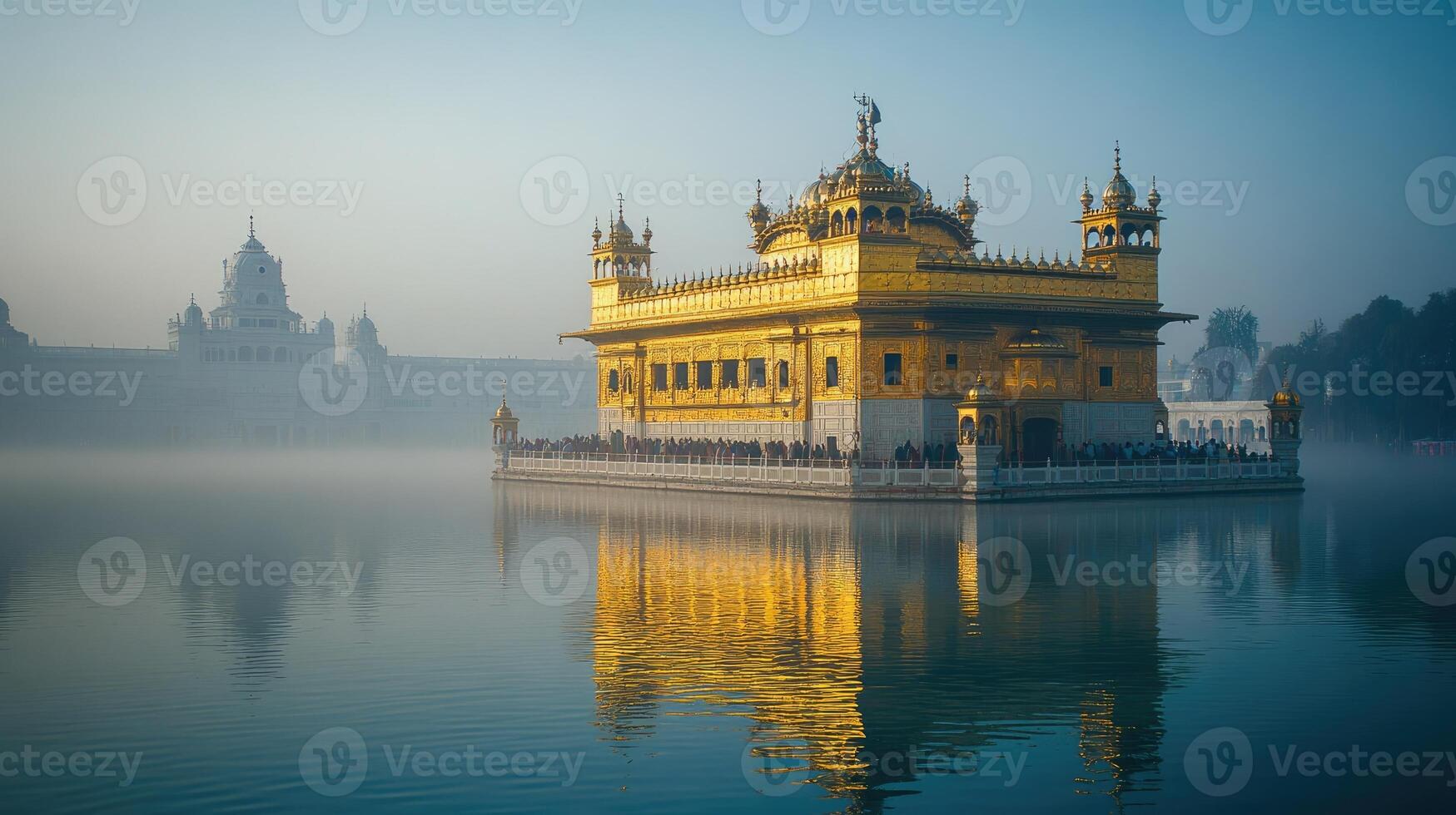 Golden temple harmandir sahib reflecting on still water with fog during sunrise in amritsar, punjab, india photo