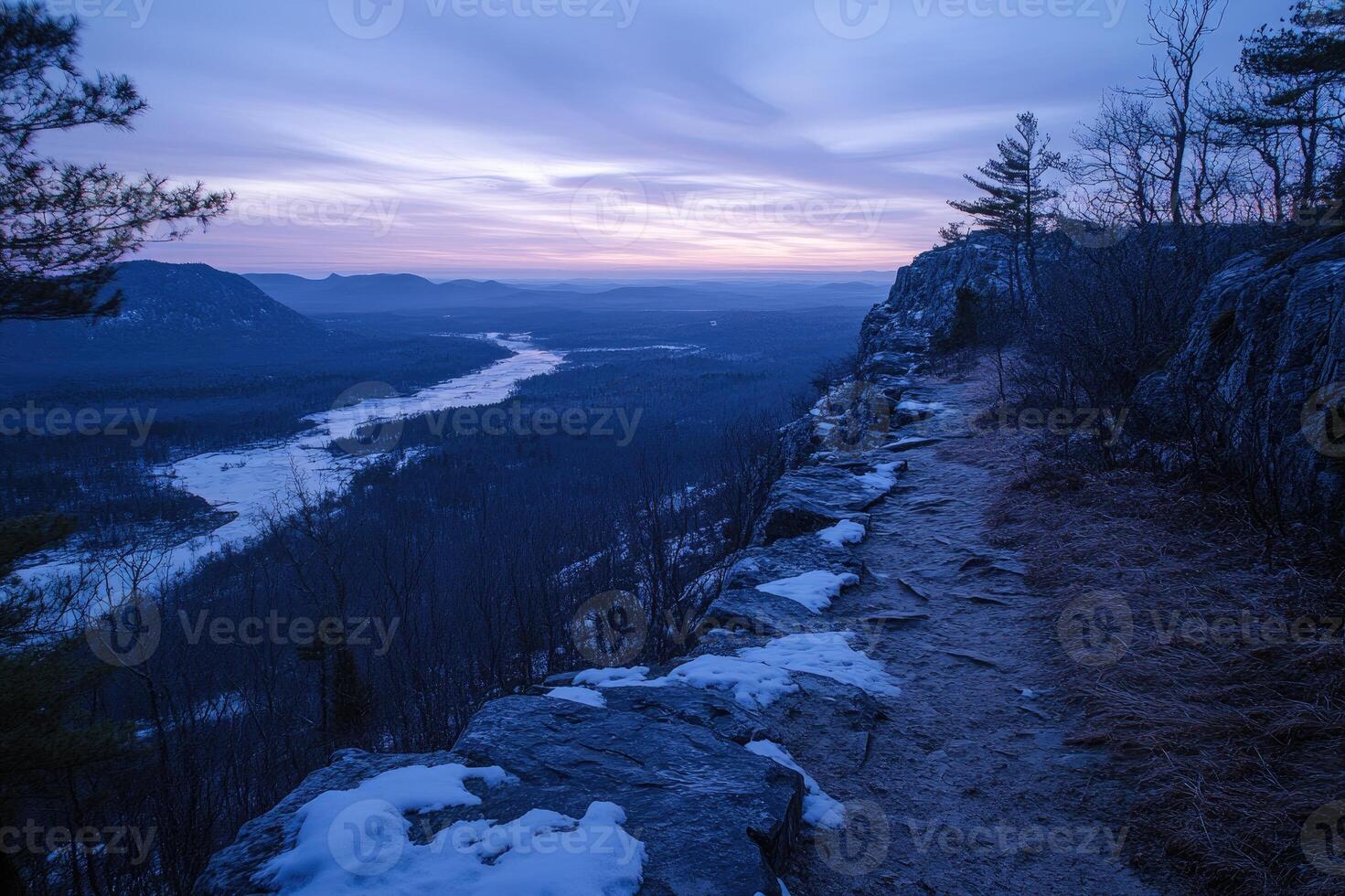 Sunrise illuminating snowy mountain path and frozen river photo