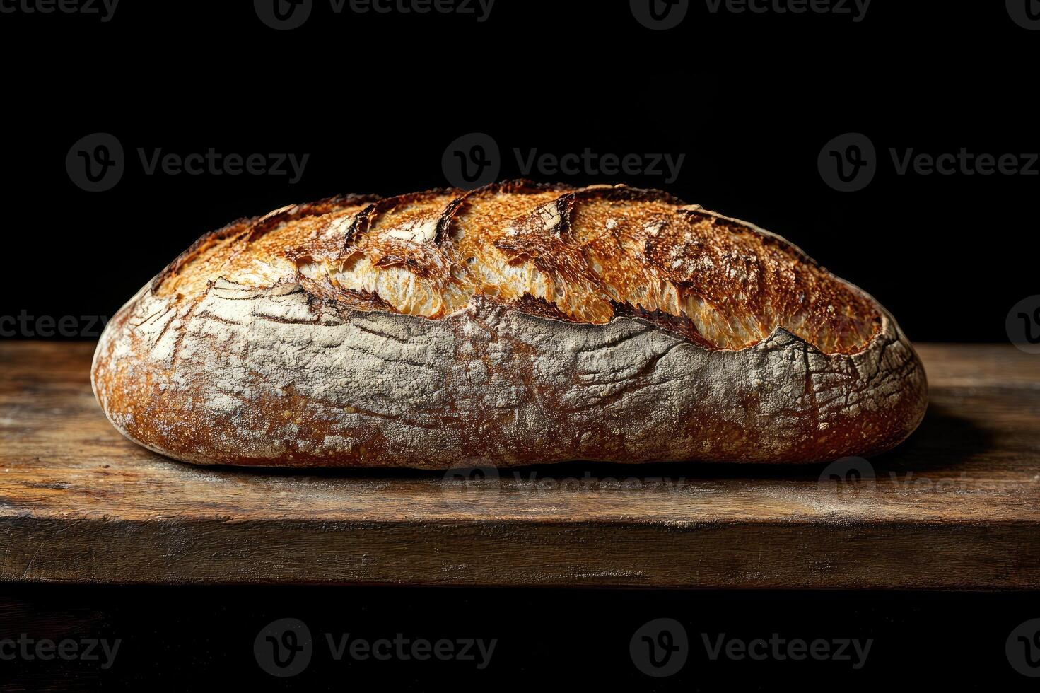 Freshly baked loaf of crusty bread resting on wooden table photo