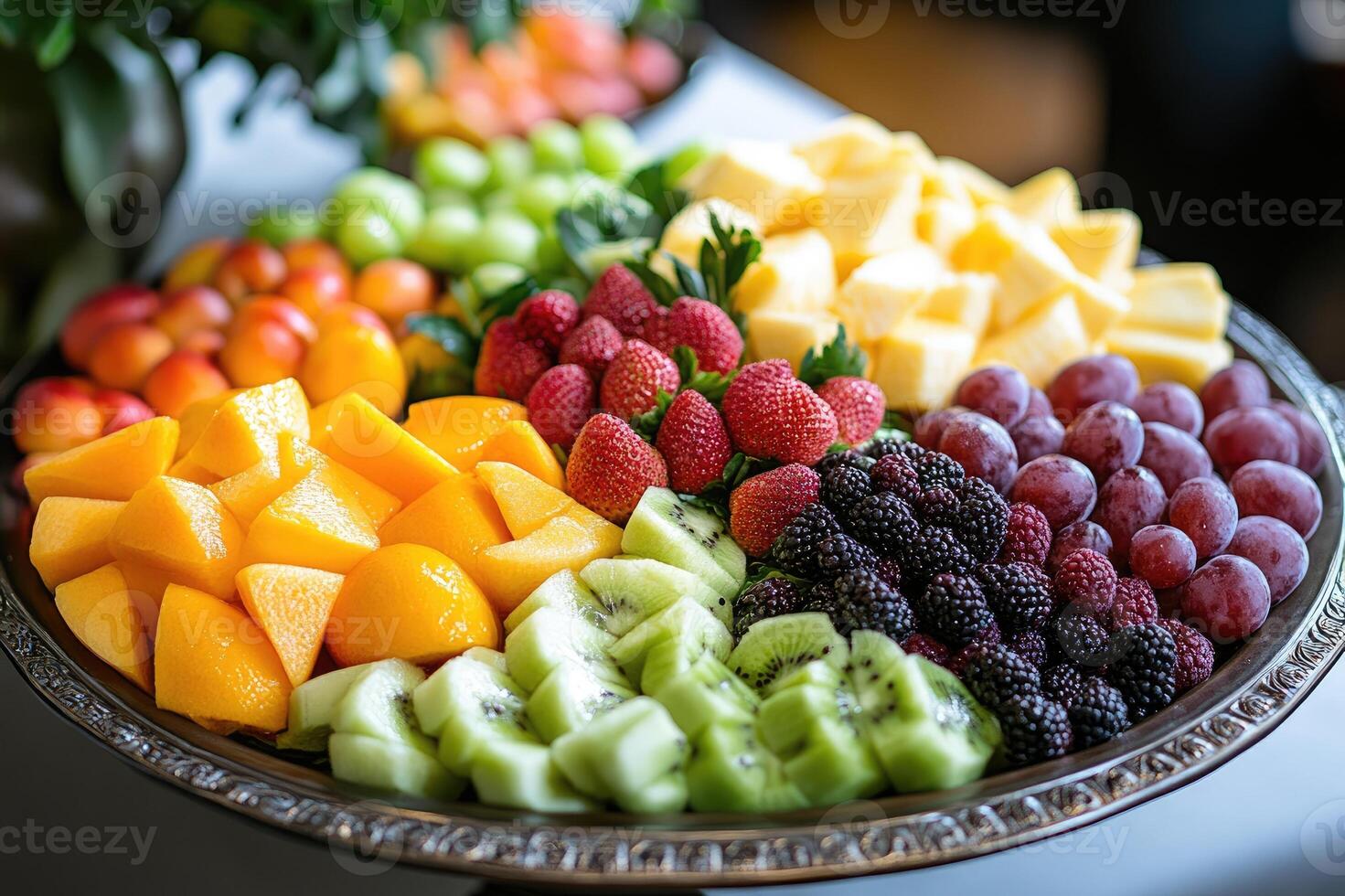 Catering showing fresh sliced fruit platter with strawberries, grapes, kiwi, pineapple, peaches and blackberries photo