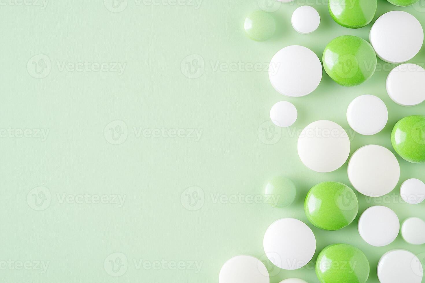 Green and white pills scattered on a light surface create an abstract pattern photo