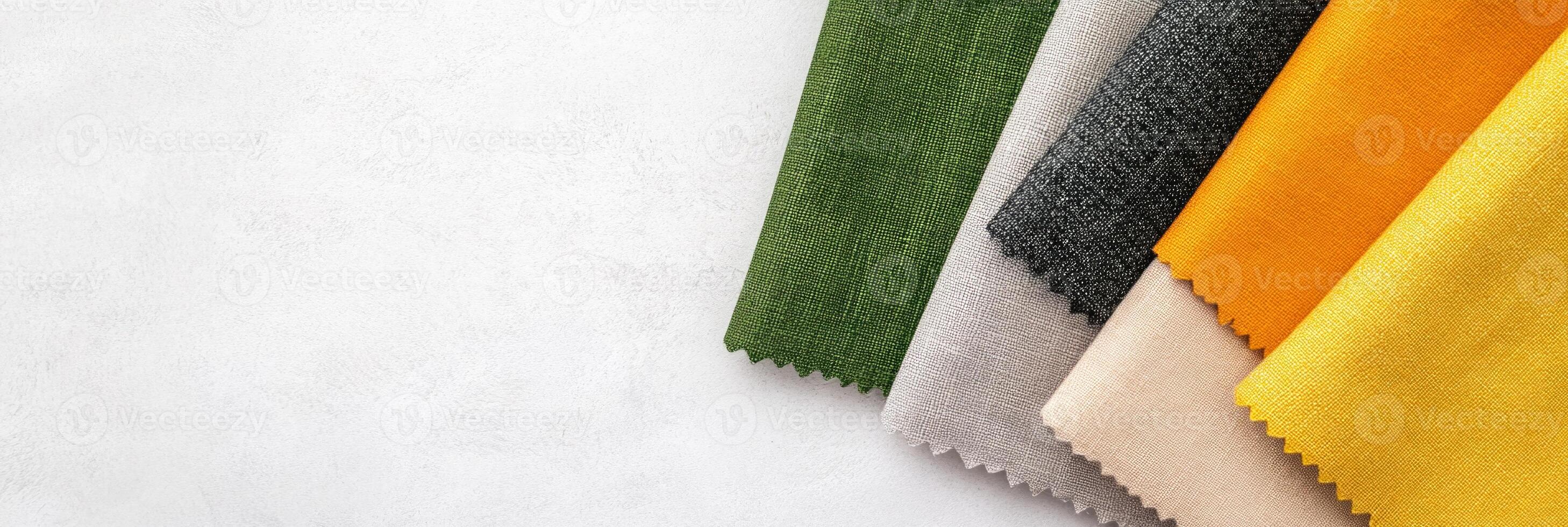 Abstract composition of layered fabric swatches in charcoal gray, green, and mustard yellow on a minimalist surface photo