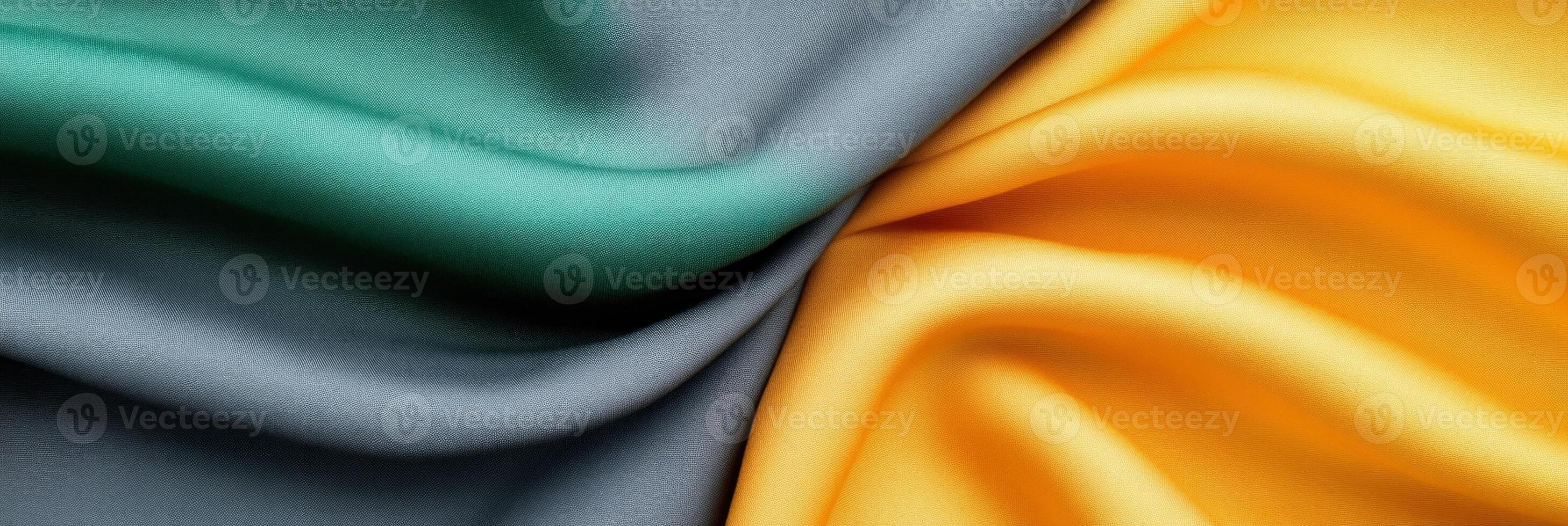 Abstract composition of soft fabric swatches in charcoal gray green and mustard yellow on a minimalist surface photo