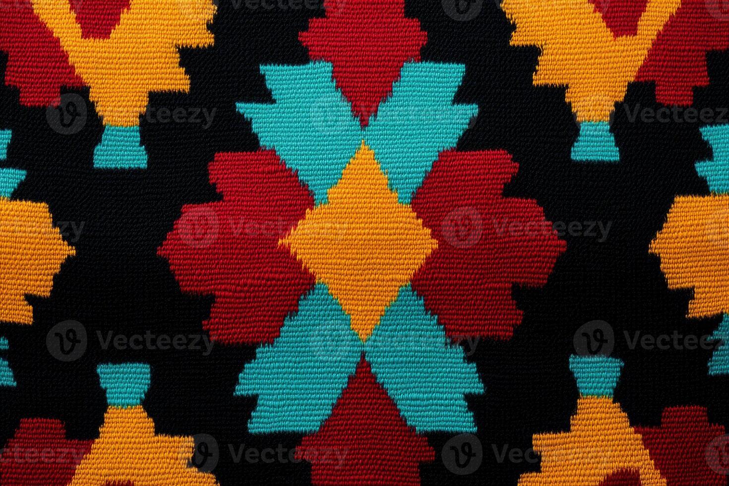 Bright Southwestern geometric pattern with red, yellow, and turquoise hues on a black fabric backdrop photo
