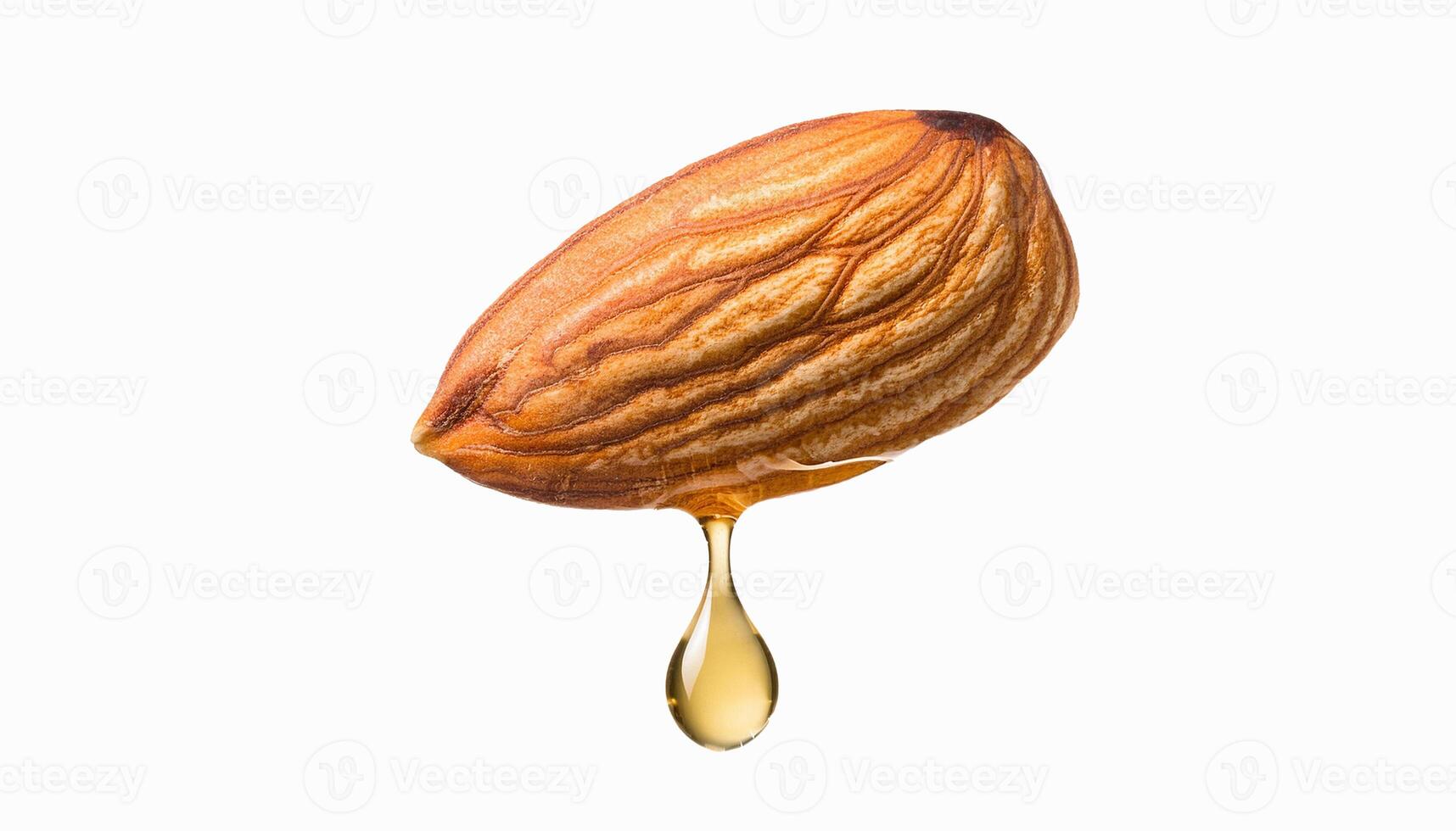 One almond nut with falling drop of oil on white isolated background. photo